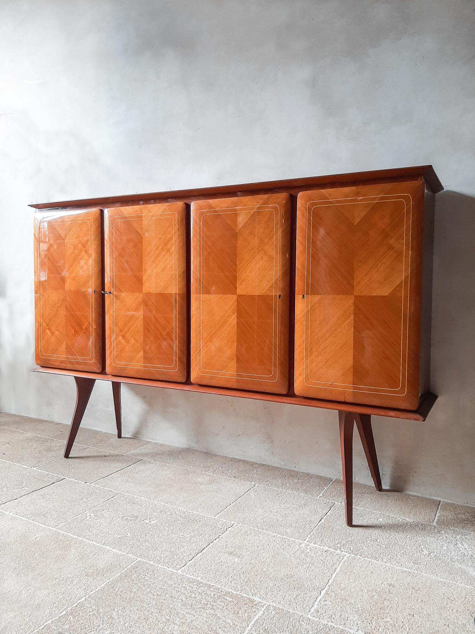 Italian vintage Paolo Buffa style sideboard from the 1950s. A mid-century high credenza or higboard in massive walnut and applied walnut veneer. The two double doors have an open leaf pattern and resin inlay, they open with the key. With internal
