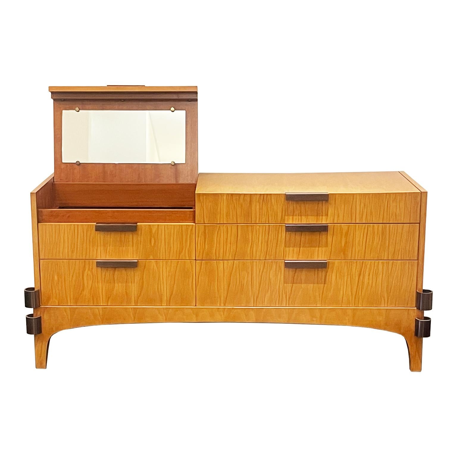 This unique Italian Mid-Century Sideboard is crafted in fir wood. This sideboard features five sleek drawers with the sixth drawer housing a hidden bar compartment with a mirror. The original handles are in an antique brass finish along with the