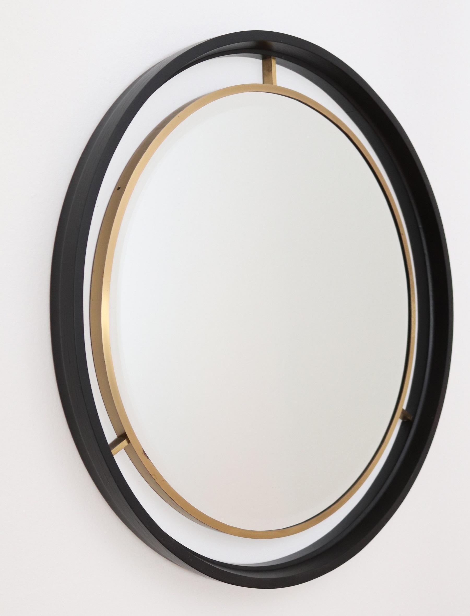 Gorgeous round wall mirror, made in Italy, during the 1960s.
With elegant cut glass in strong internal brass frame, which is fixed inside a bigger dark varnished plywood frame made of mahogany.
The mirror is of quality manufacturing without any