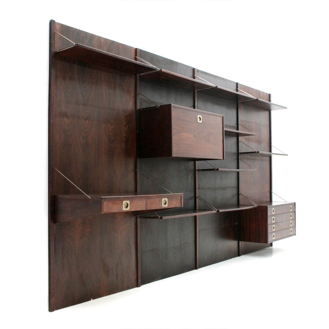 Large wall bookcase produced in the 1960s by Stildomus.
Solid wood uprights and back panels in veneered wood.
Mobile bar compartment, chest of drawers, shelves and desk with two drawers in veneered wood.
Handles and shelf supports, in