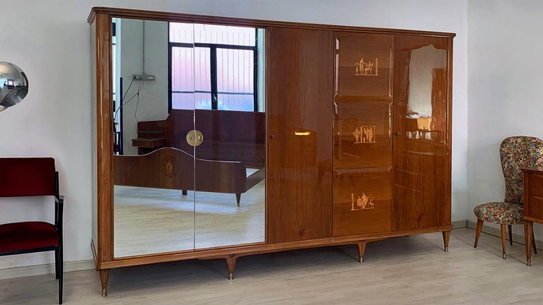 Stylish Italian Armoire with five doors of the 1950s, attributed to Paolo Buffa.
Its structure is made of a gorgeous lacquered Italian walnut, externally decorated with refined inlays and supported with tapered legs finished with brass feet.
All