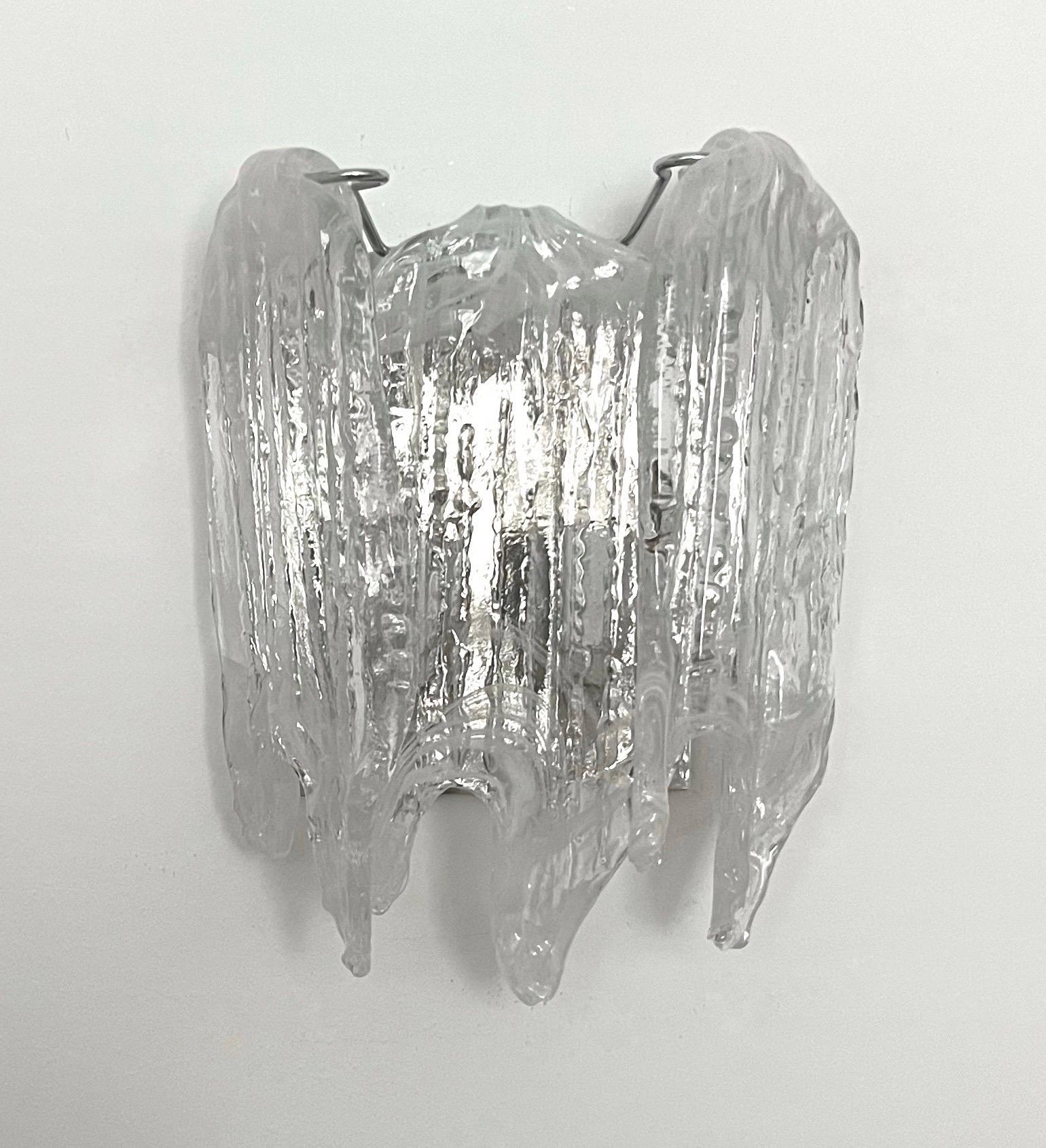 Preciosa lámpara de pared italiana de cristal de Murano blanco transparente de la década de 1970. Esta luminaria fue diseñada y fabricada durante la década de 1970 en Italia por Mazzega. 
El aplique está equipado con 1 portalámparas E14. Un