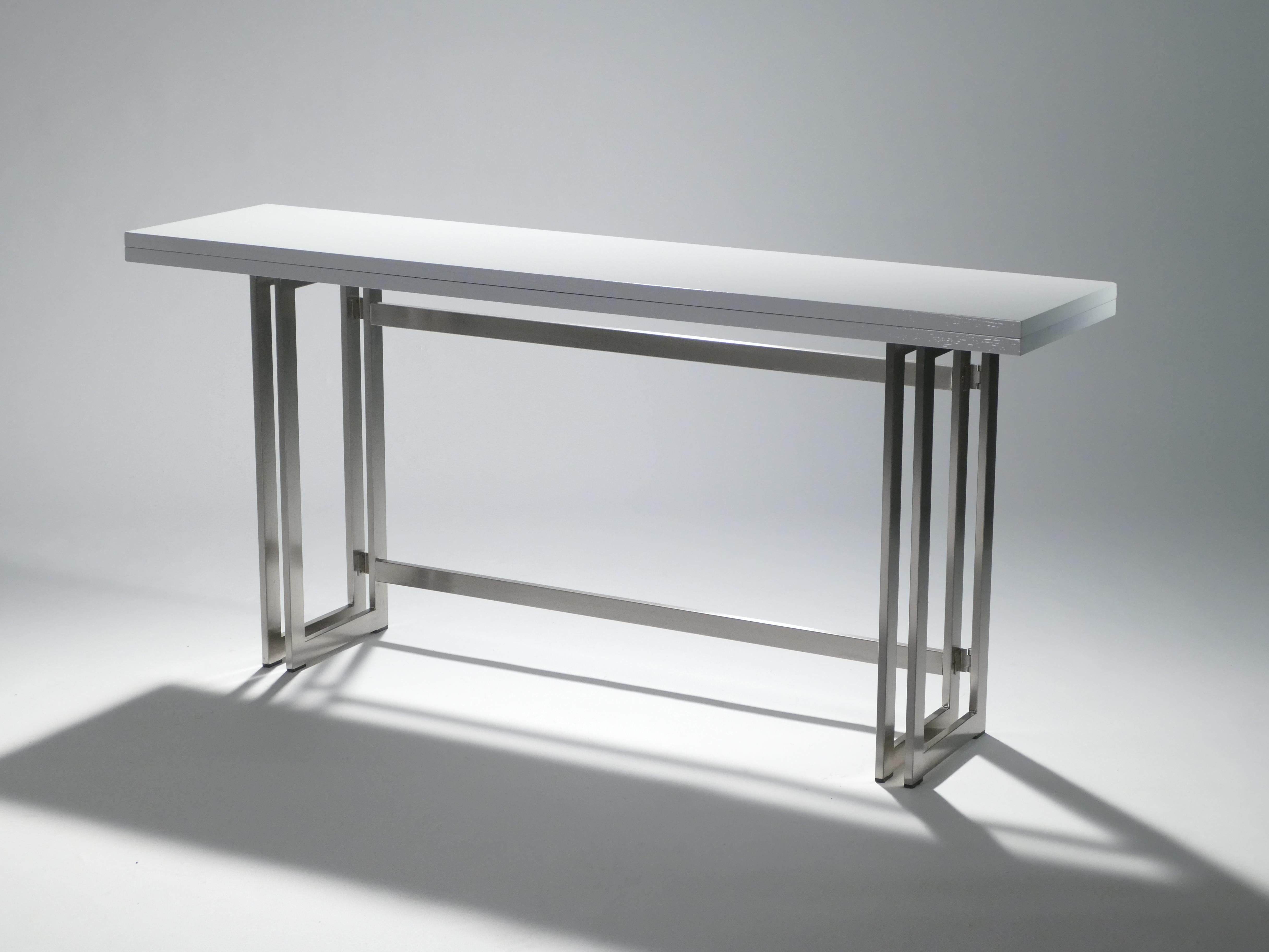 With a shining white lacquered top, sharply geometric brushed metal legs and a foldable body to fit your particular spatial needs, this midcentury Italian console table by Artelano carries a stellar futuristic midcentury aesthetic into the