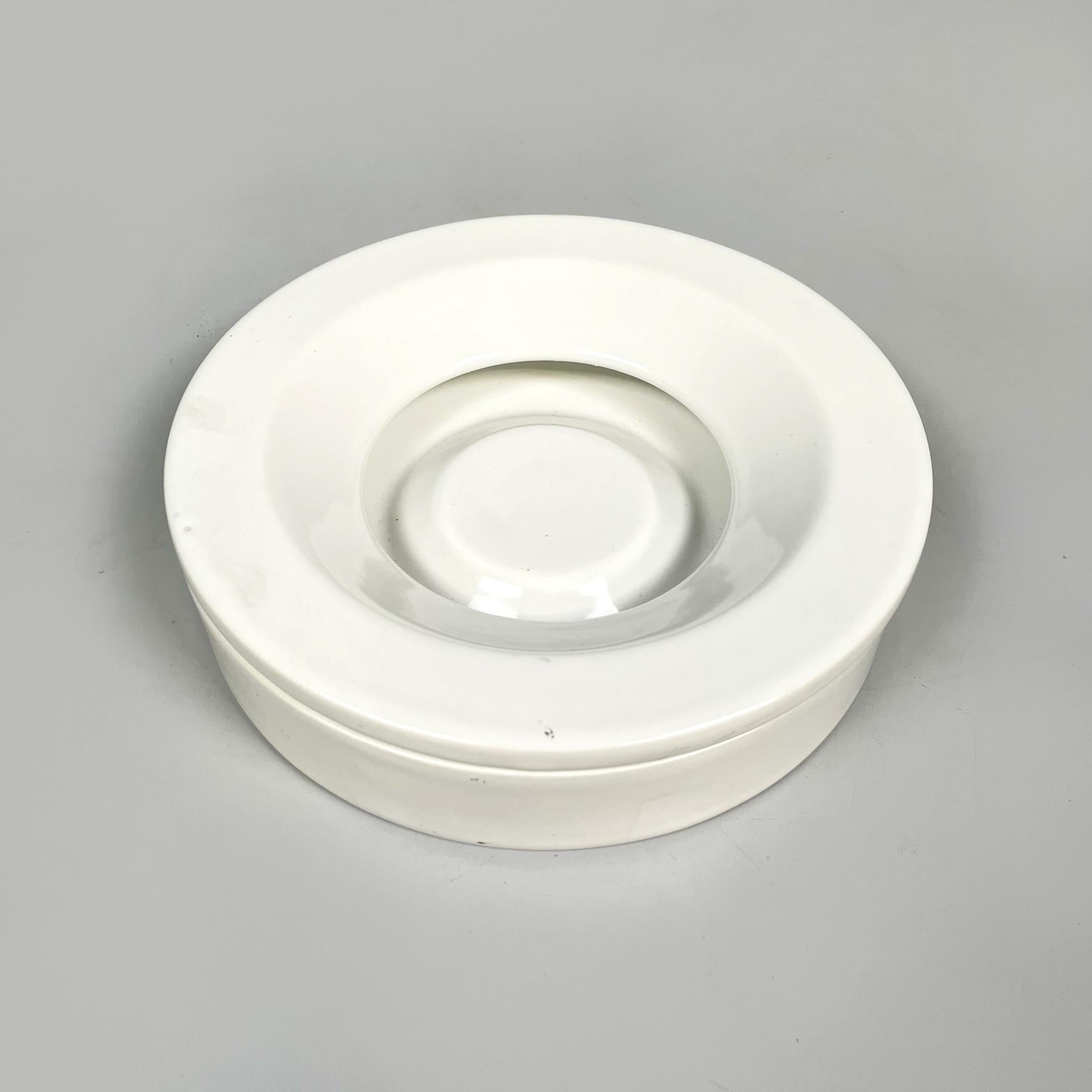 Italian Mid-Century White Porcelain Stoneware Ashtray by Angelo Mangiarotti for Danese, 1970s
Round ashtray with cover in white porcelain stoneware. The plate has a slight rise in the central area. The cover is donut-shaped and tends to sag towards