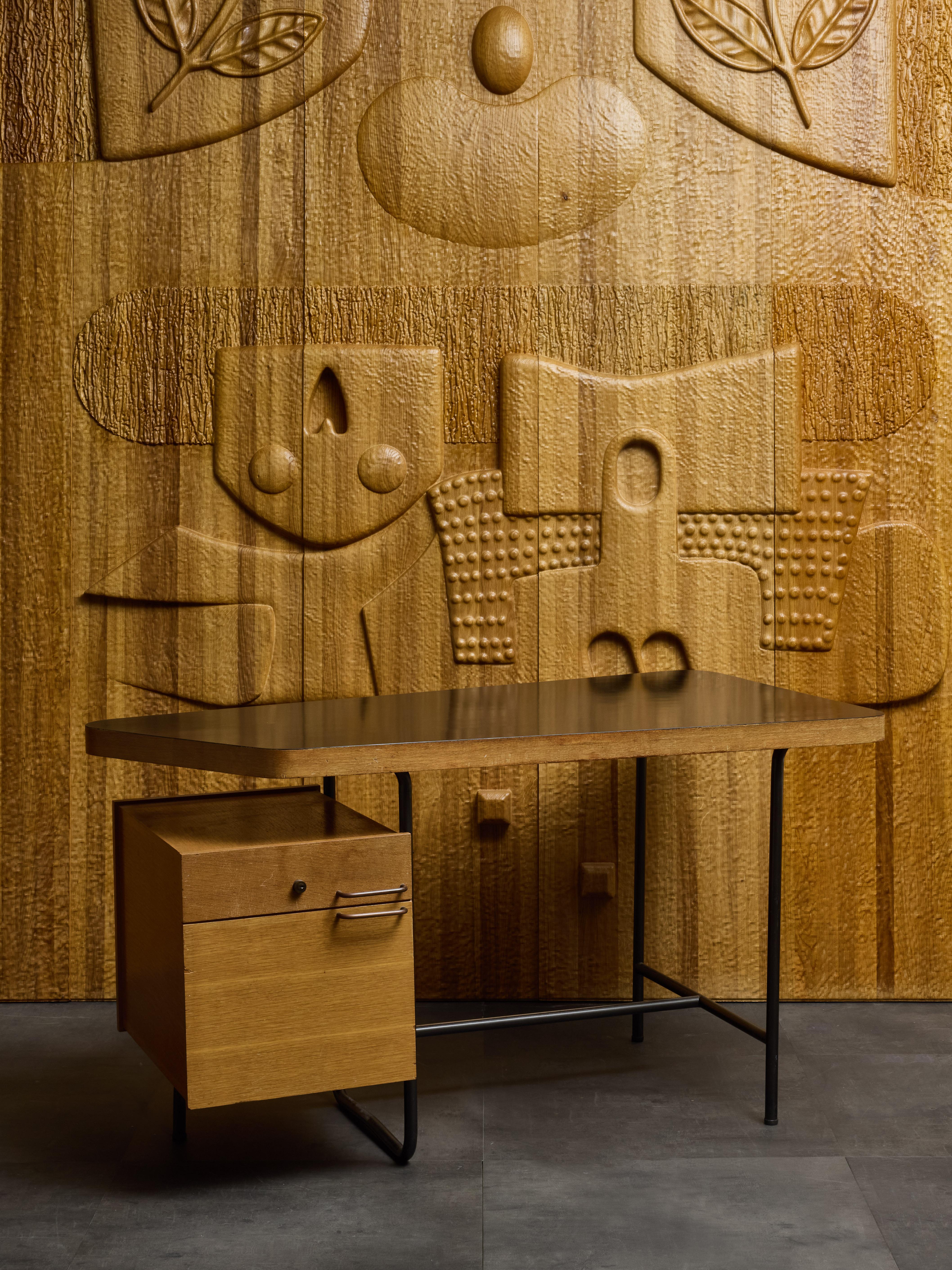 Kleiner Schreibtisch aus der Mitte des Jahrhunderts mit Metallfüßen und Holzschränken und -platte.

Die Schreibfläche ist mit einer schwarzen Laminatschicht überzogen, die den Kontrast zu den Schubladen hervorhebt. Sie ist leicht asymmetrisch und