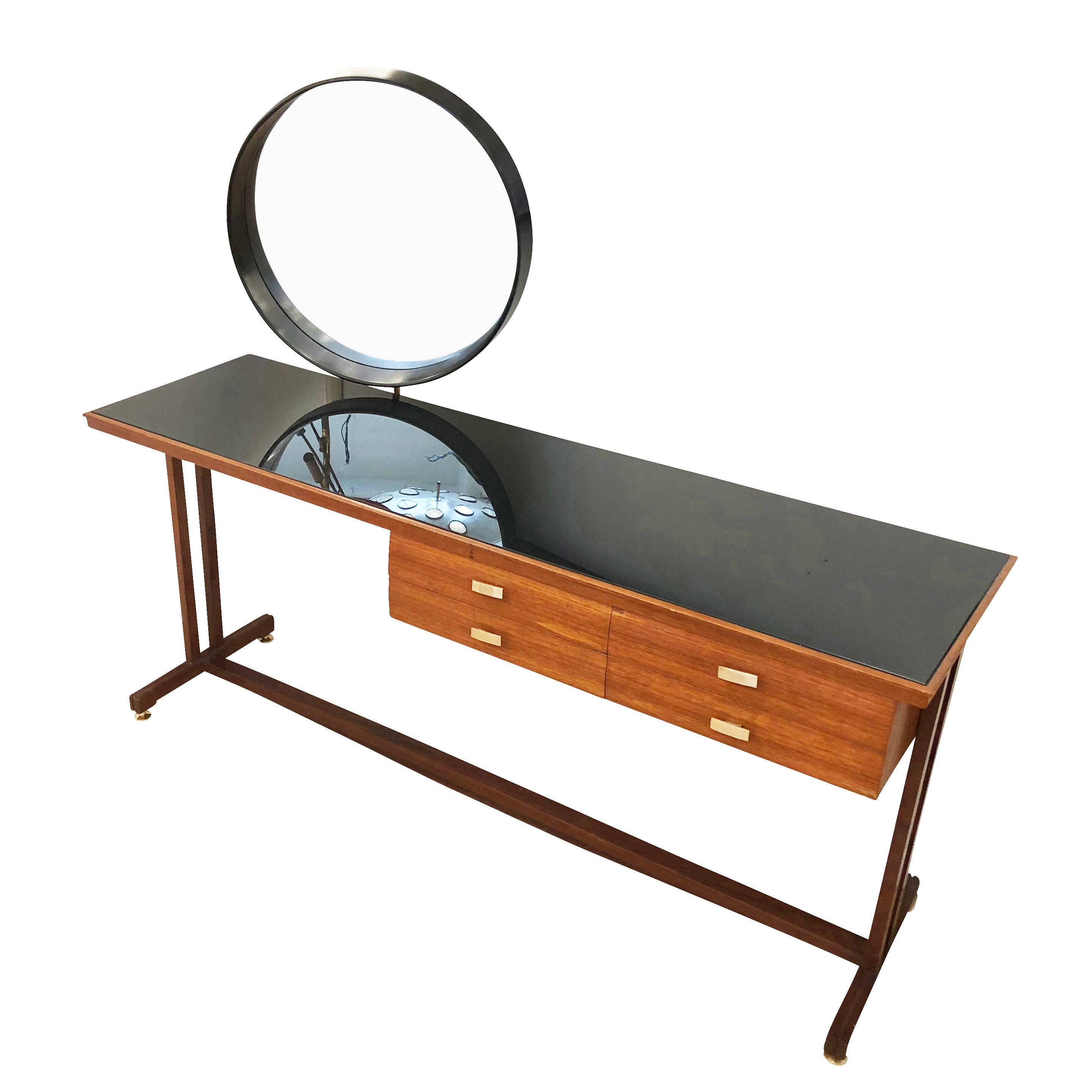 Beautiful midcentury wood vanity with a black glass top, round mirror and brass details. The mirror can be removed so that it can be used as a narrow desk. 

Condition: Excellent vintage condition, minor wear consistent with age and use. A couple