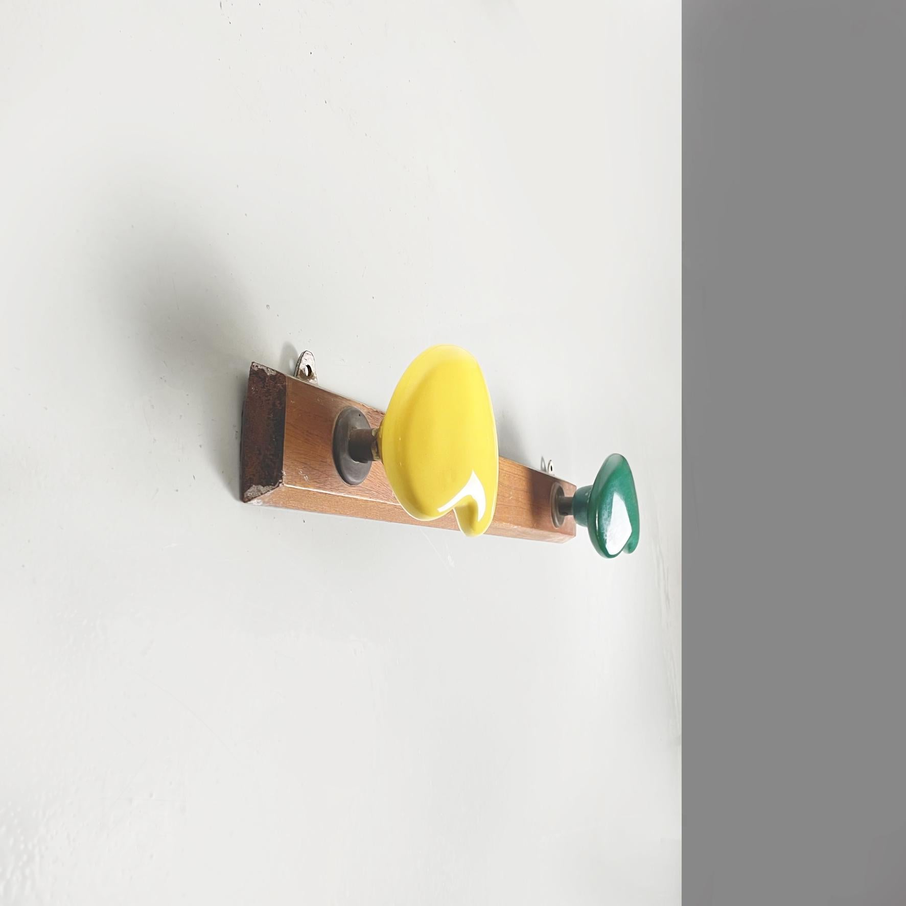 Italian midcentury Wall hanger in wood with hooks in green yellow ceramic, 1960s.
Wall hanger with rectangular wooden structure. On the front there are two hooks with an asymmetrical shape in forest green and yellow ceramic.
1960s
Good