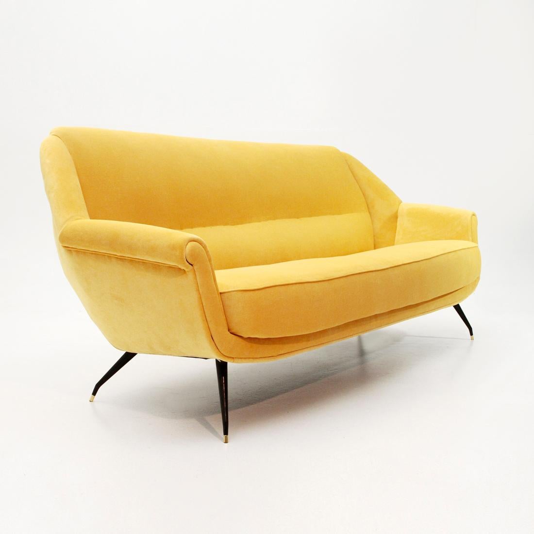 Italian manufacturing sofas produced in the 1950s.
Wooden frame padded and lined with new fabric in yellow velvet.
Base in curved metal and black painted with brass terminal. 
Good general conditions, some signs due to normal use over