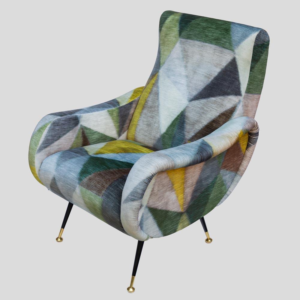 A vintage mid century armchair black enamelled legs with brass feet, re-upholstered in a geometrical patterned velvet in green dark and lighter grey light and darker amber a design attributed to Zanuso made in Italy.