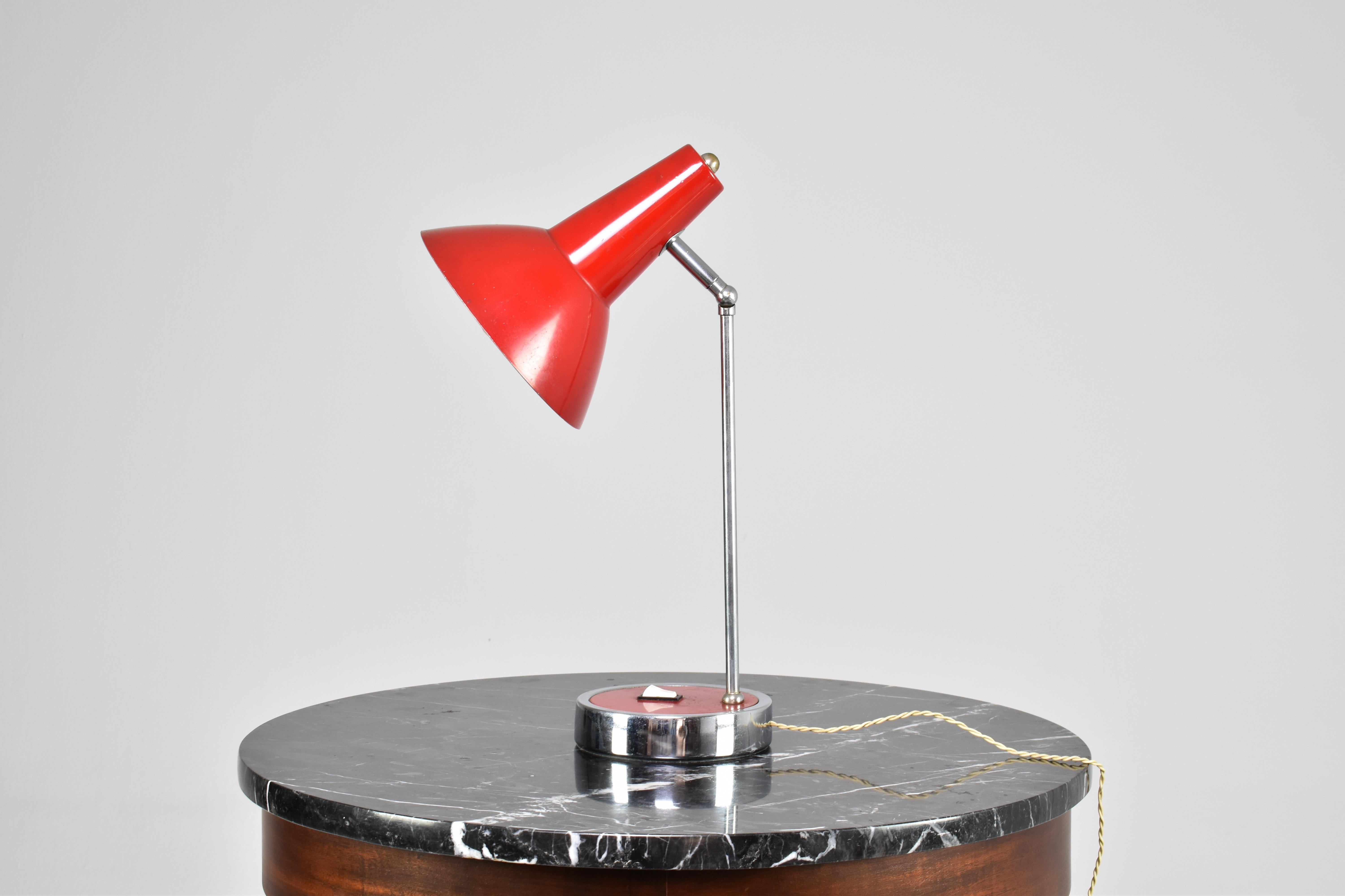 Elegante lampada da scrivania vintage del XX secolo con paralume originale girevole di colore rosso vivo e braccio cromato con interruttore alla base. Attribuito a Stilnovo. 
Cablaggio originale, verificato professionalmente. 

Gli standard E27 e
