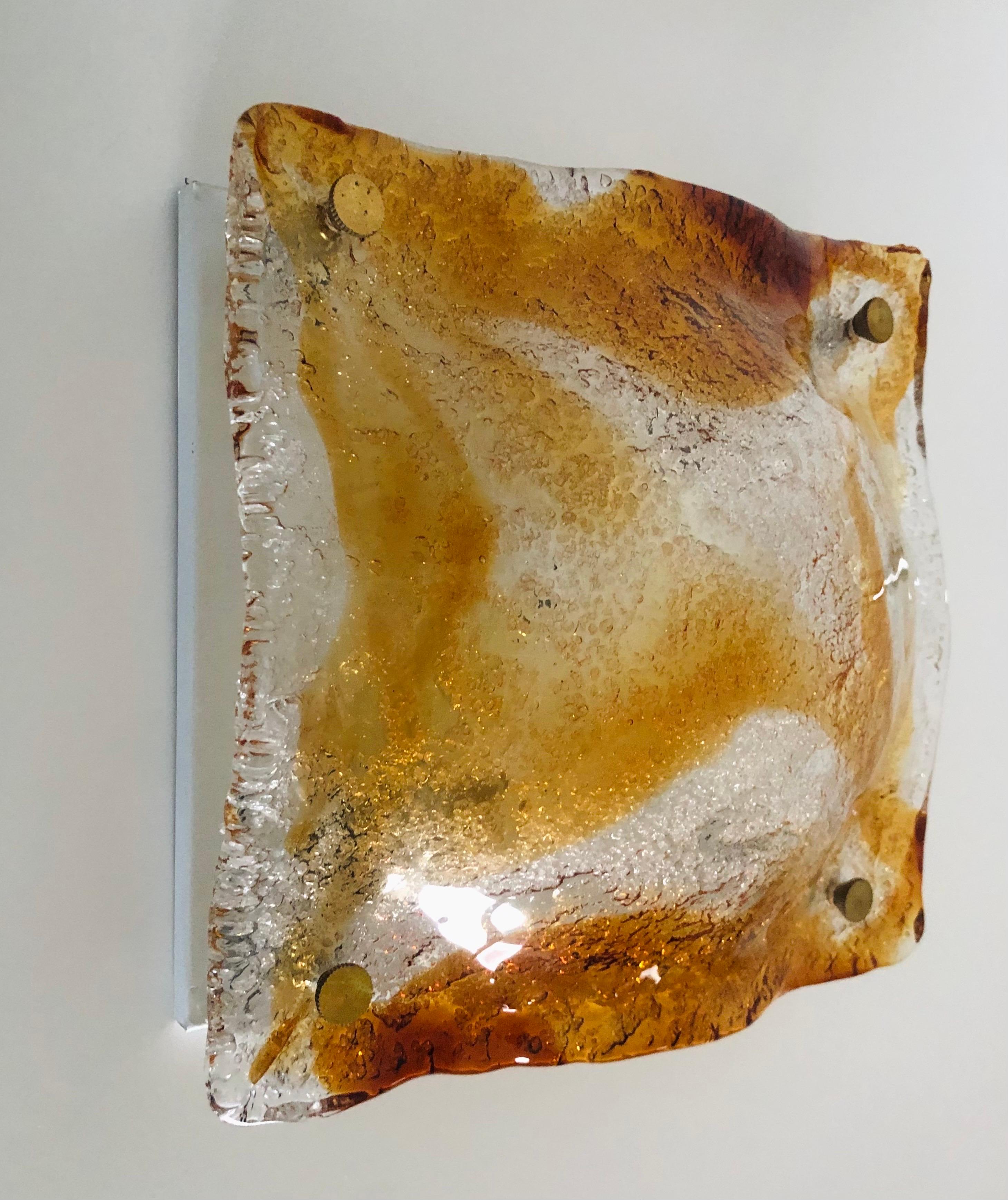 Hübscher italienischer Wandleuchter aus bernsteinfarbenem Murano-Glas aus den 1970er Jahren. Dieser Wandleuchter  wurde in den 1970er Jahren in Italien entworfen und hergestellt.
Dieser Wandleuchter ist mit 2 E14-Fassungen ausgestattet. Ein