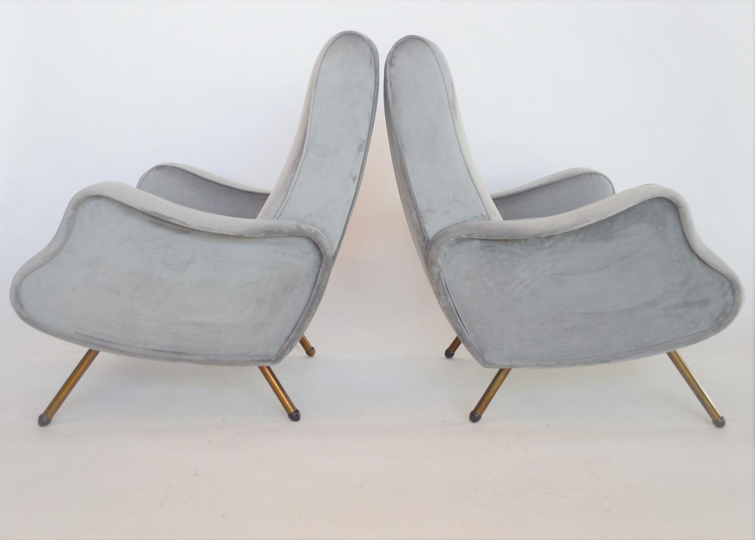 Beautiful and very comfortable pair of Italian midcentury armchairs or lounge chairs, original of the 1950s, manufactured in Turin.
A very special shape with the soft wave shape of the armrests and the wooden feet in spherical shape.
The armchairs