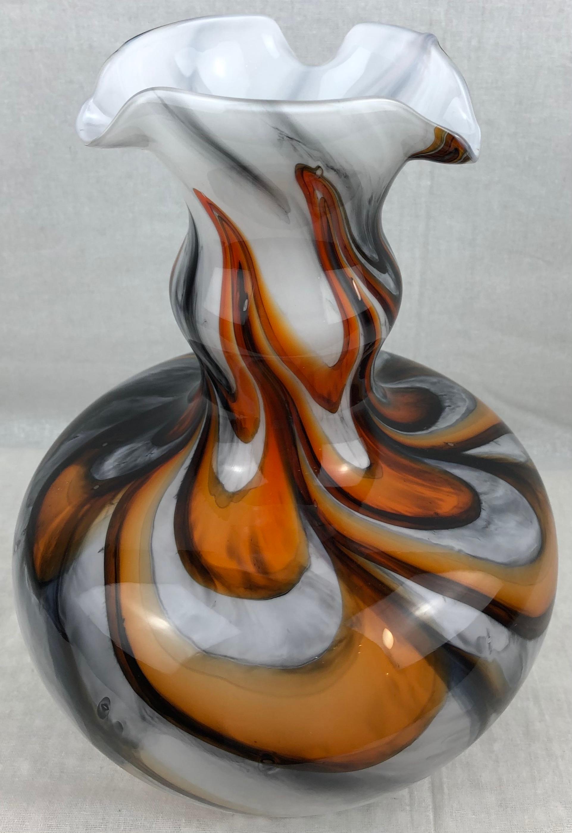 A beautiful white, black and orange art glass vase with swirl motifs. Perfect for displaying on a table, any shelf or counter top. 

Measures: Height 9 5/8 inches
Diameter: 6 3/8 inches

Perfect vintage condition, no cracks or chips.

 
