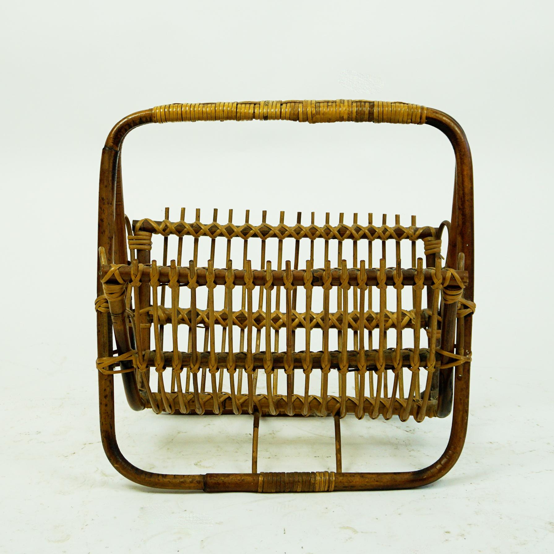 This charming Italian midcentury bamboo and wicker magazine holder or rack has been designed and manufactured in Italy 1960s. 
It´s style and manner of wickerwork reminds to furniture pieces designed by Franco Albini for Bonacina and will be a