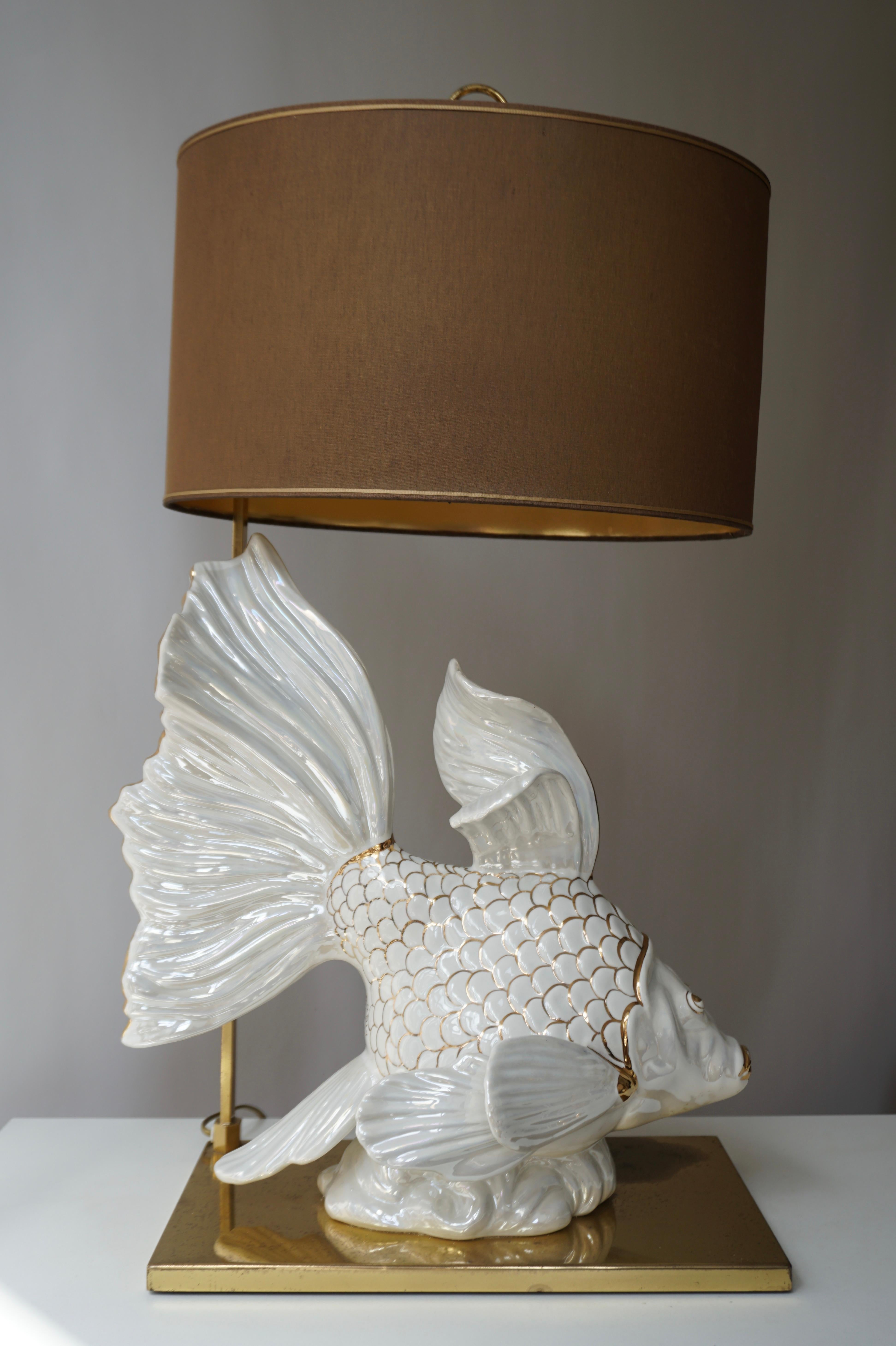 Wunderschöne Tischlampe mit Fischen aus weißer Keramik, handgefertigt und handbemalt mit Goldplatte auf einem Messingfuß.

 

 