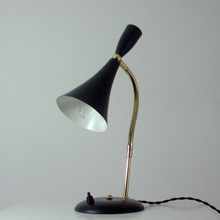 This midcentury table lamp was manufactured in Italy in the 1950s.

It has got an adjustable black lacquered lampshade and a brass goose neck lamp arm.
The lamp has been rewired and partly restored. It is in very good condition and ready for use