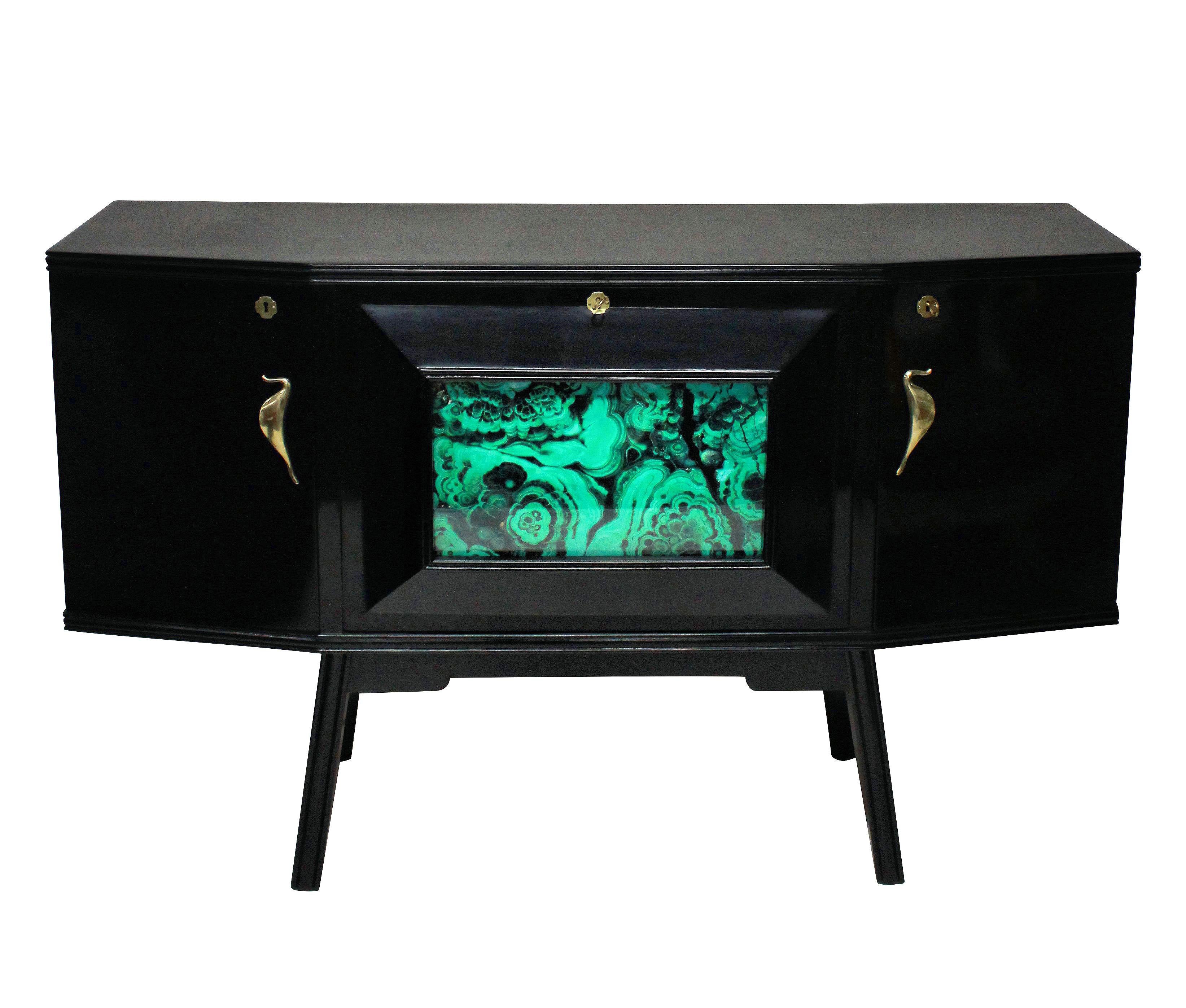 A stylish Italian bar credenza of interesting angular design in black lacquer with sepele wood interior, with brass hardware and a faux malachite central panel and mirrored interior.

        
