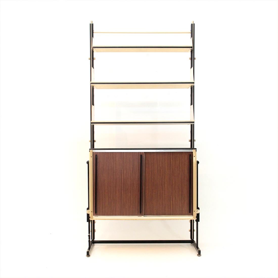 Italian manufacture bookshop produced in the 1960s.
Uprights in black painted metal with brass-plated metal details.
Wooden shelves covered in faux leather and brass-plated metal brackets.
Container with faux white leather sides, upper top in