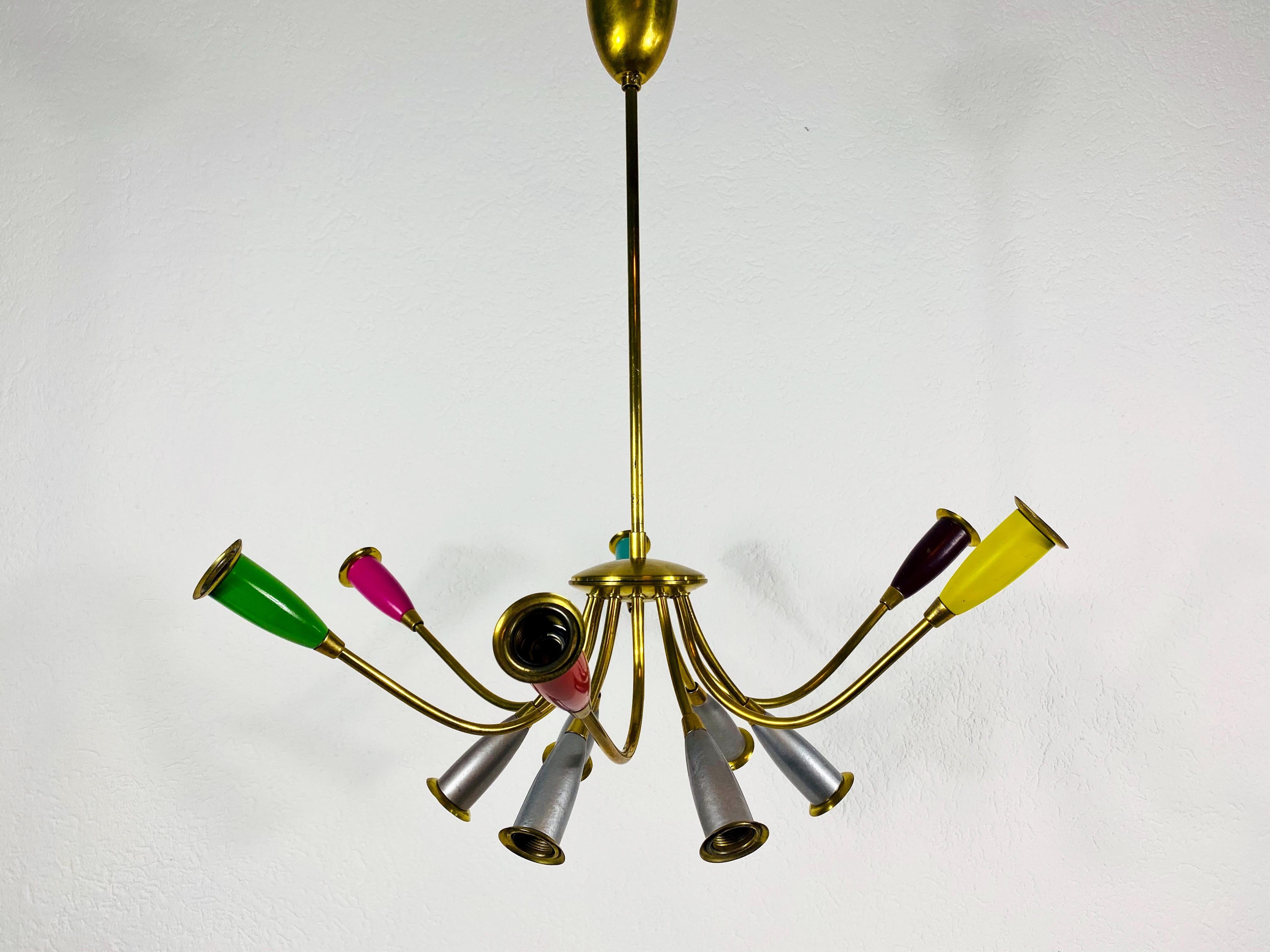 A colorful Sputnik chandelier attributed to Arredoluce and made in Italy in the 1950s. It is fascinating with its twelve brass arms, each of it with an E14 light bulb. The shape of the light is similar to a spider.

The light requires 12 E14 light
