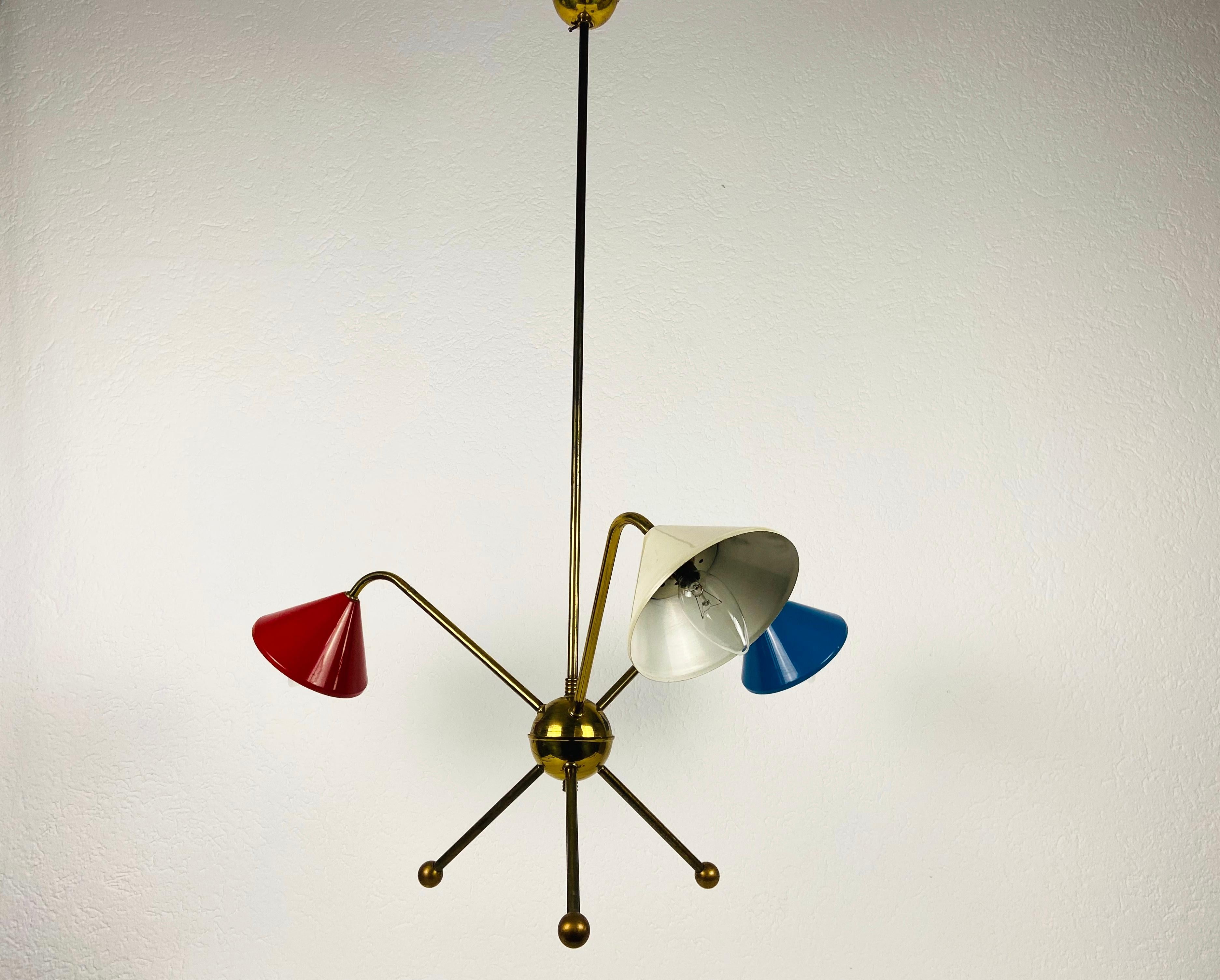 A Sputnik chandelier made in Italy in the 1950s and attributed to Arredoluce. It is fascinating with its three brass arms, each of it with an E14 light bulb. 

The light requires 3 E14 light bulbs. Good vintage condition. Works with both 120/220