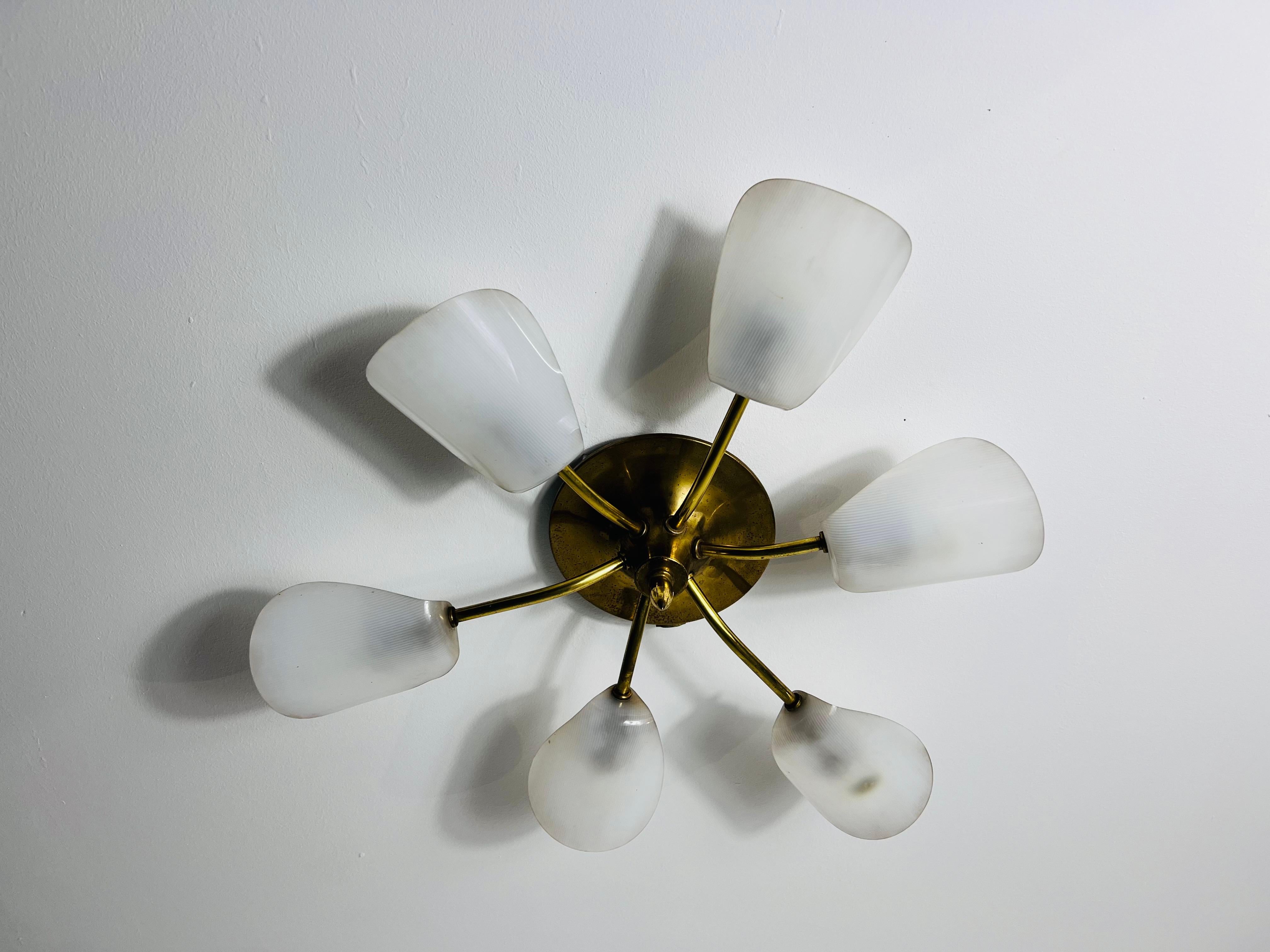Questa lampada da soffitto Sputnik italiana degli anni '50 è un esempio accattivante di design moderno di metà secolo nello stile di Stilnovo. Whiting a sei bracci con paralumi in vetro acrilico bianco e prese in ottone, questa lampada emana