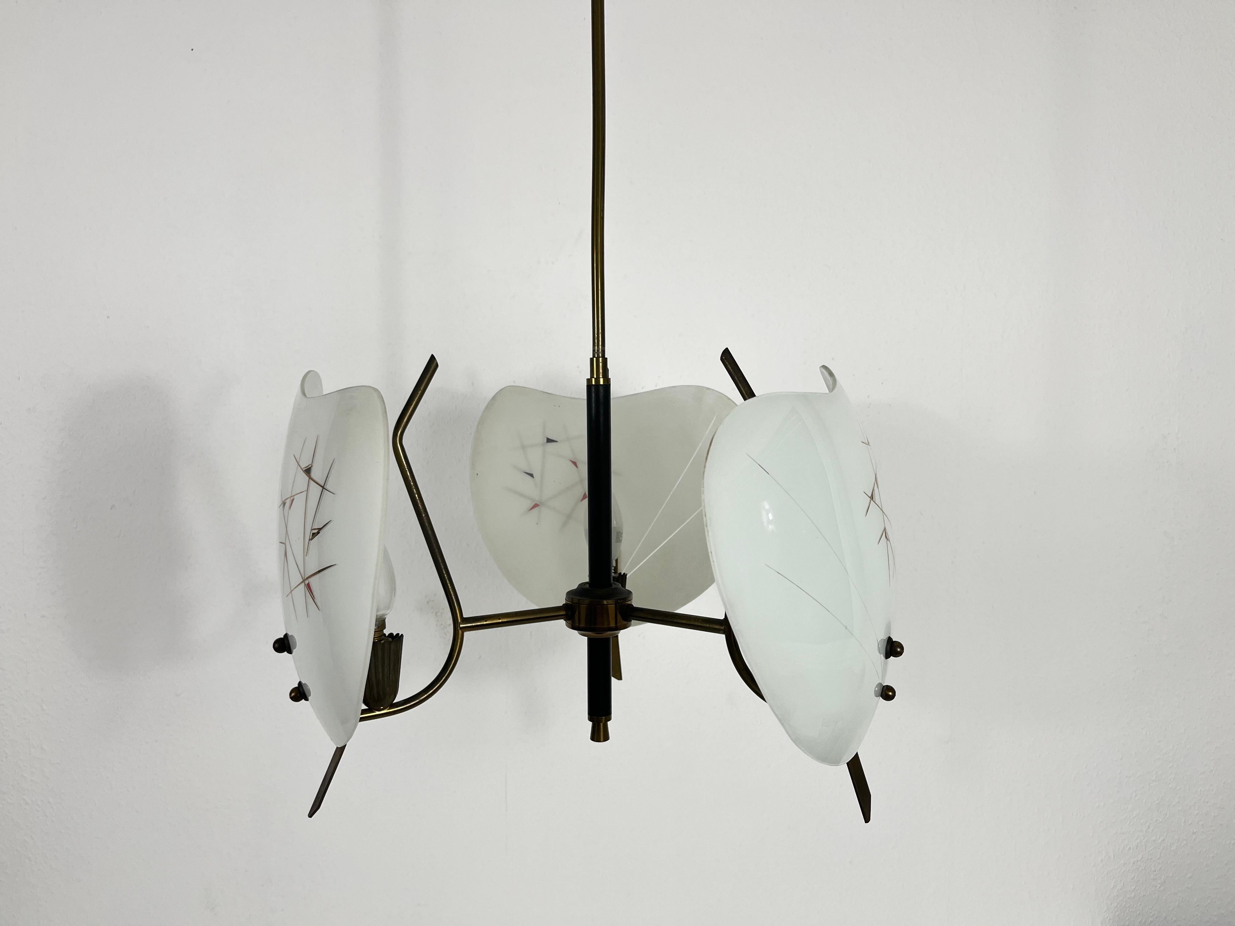 Ein Sputnik-Kronleuchter, der in den 1950er Jahren in Italien hergestellt wurde. Er fasziniert mit seinen drei Messingarmen, die jeweils mit einem besonderen Glasornament versehen sind.

Die Leuchte benötigt 3 E14-Glühbirnen. Guter alter