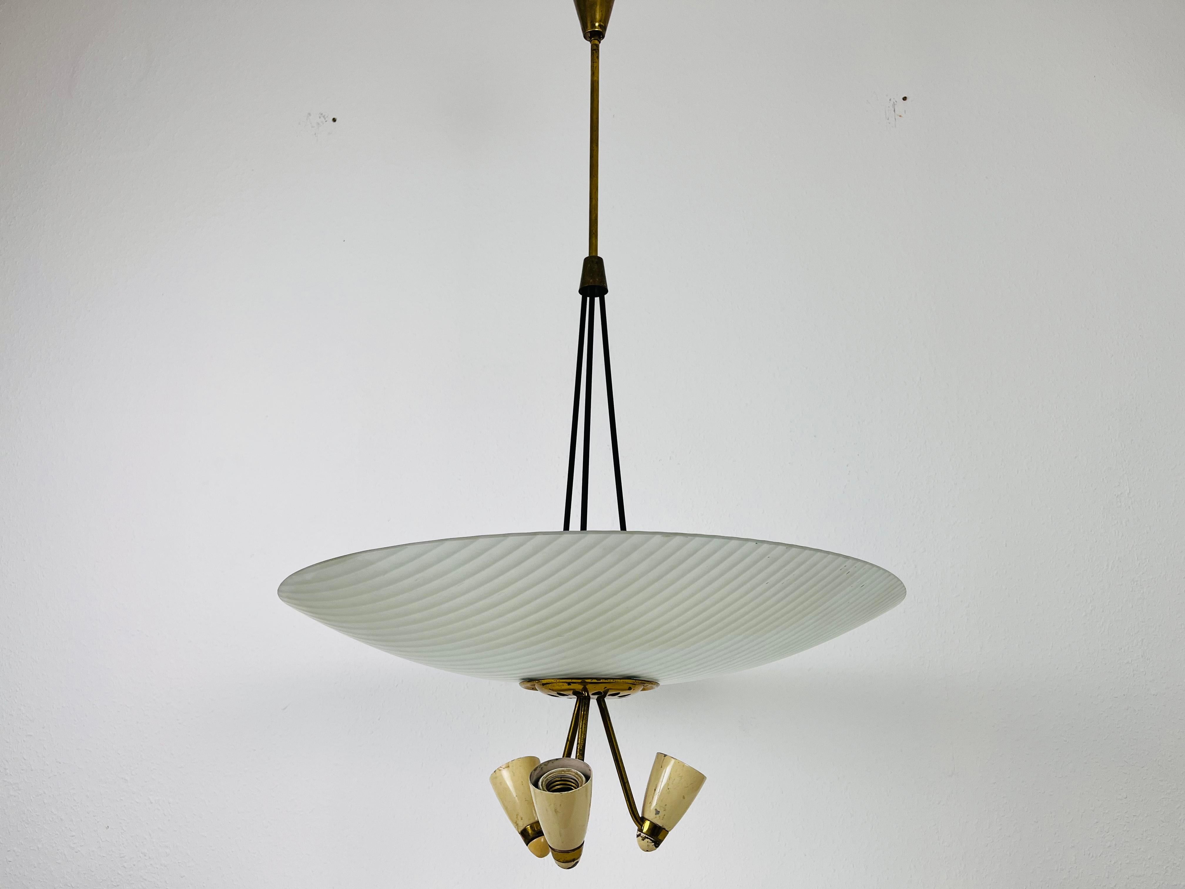 A Sputnik chandelier made in Italy in the 1950s. It is fascinating with its unique saucer shape and wonderful brass elements.

The light requires 3 E27 (US E26) light bulbs under the glass element. Good vintage condition.

Free worldwide express