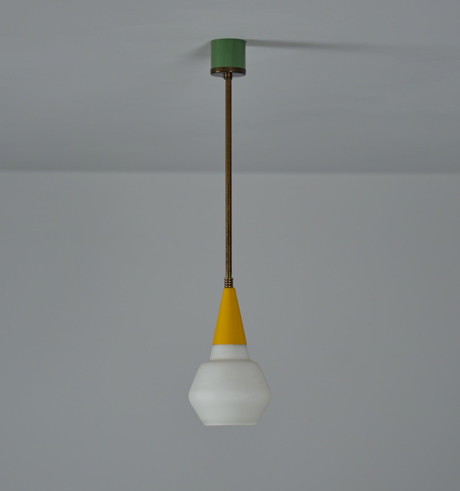 Italian midcentury ceiling pendant light, crafted in the 1950s with a fusion of timeless elegance and modern design. This small single-bulb fixture features a stunning combination of brass and lacquered metal in vibrant yellow and green hues,