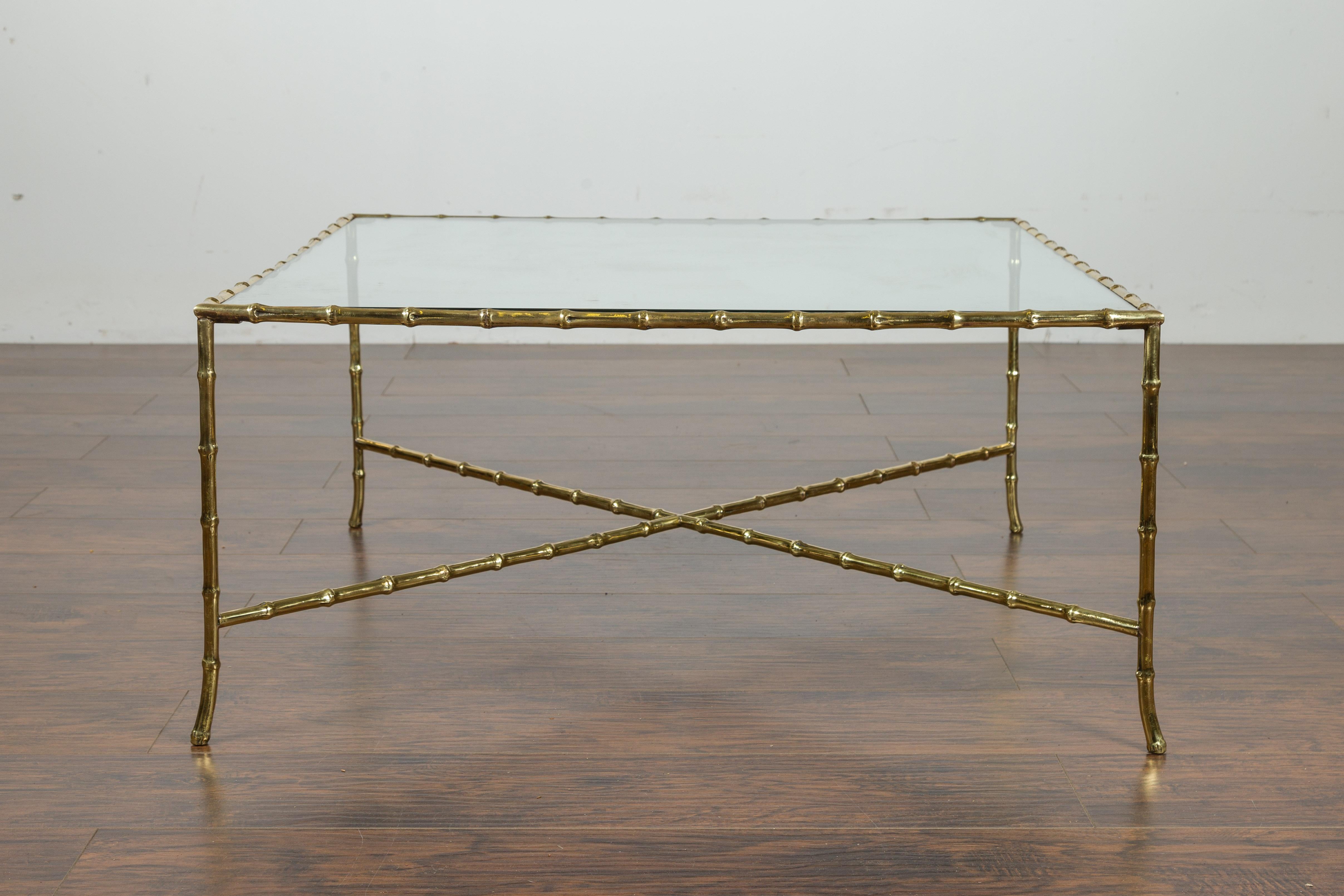 An Italian vintage brass coffee table from the mid-20th century, with glass top and faux bamboo base. Created in Italy during the midcentury period, this brass coffee table features a rectangular glass top sitting above an eye-catching faux-bamboo