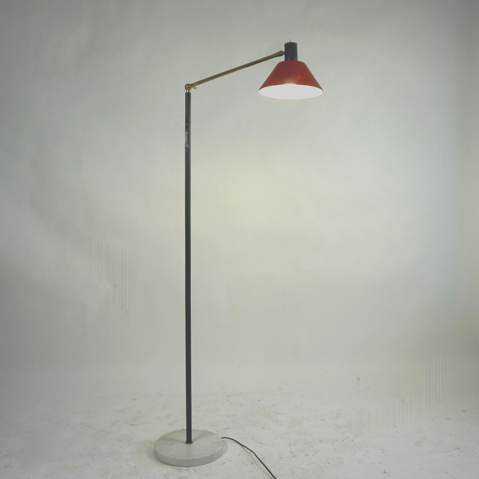 This charming Italian Midcentury adjustable floor lamp has been designed in Italy and edited by Stilux in the 1950s It features a brass and metal stem with a red lacquered shade and a marble base.
Thanks to the brass arm and the little handle it s