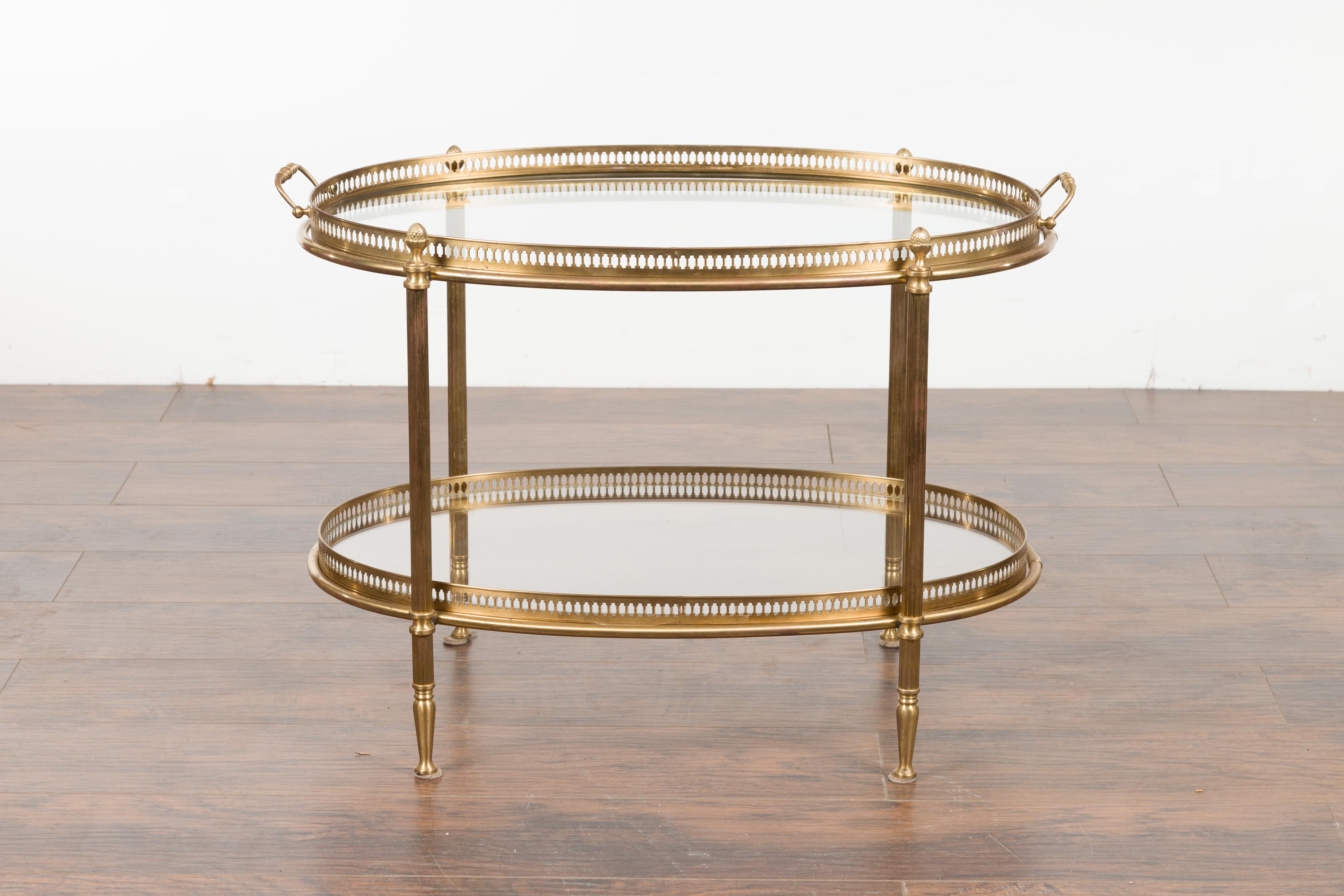 An Italian vintage brass oval side table from the mid 20th century, with pierced gallery and glass shelves. Created in Italy during the midcentury period, this oval side table features an oval glass top surrounded by a delicate pierced gallery,