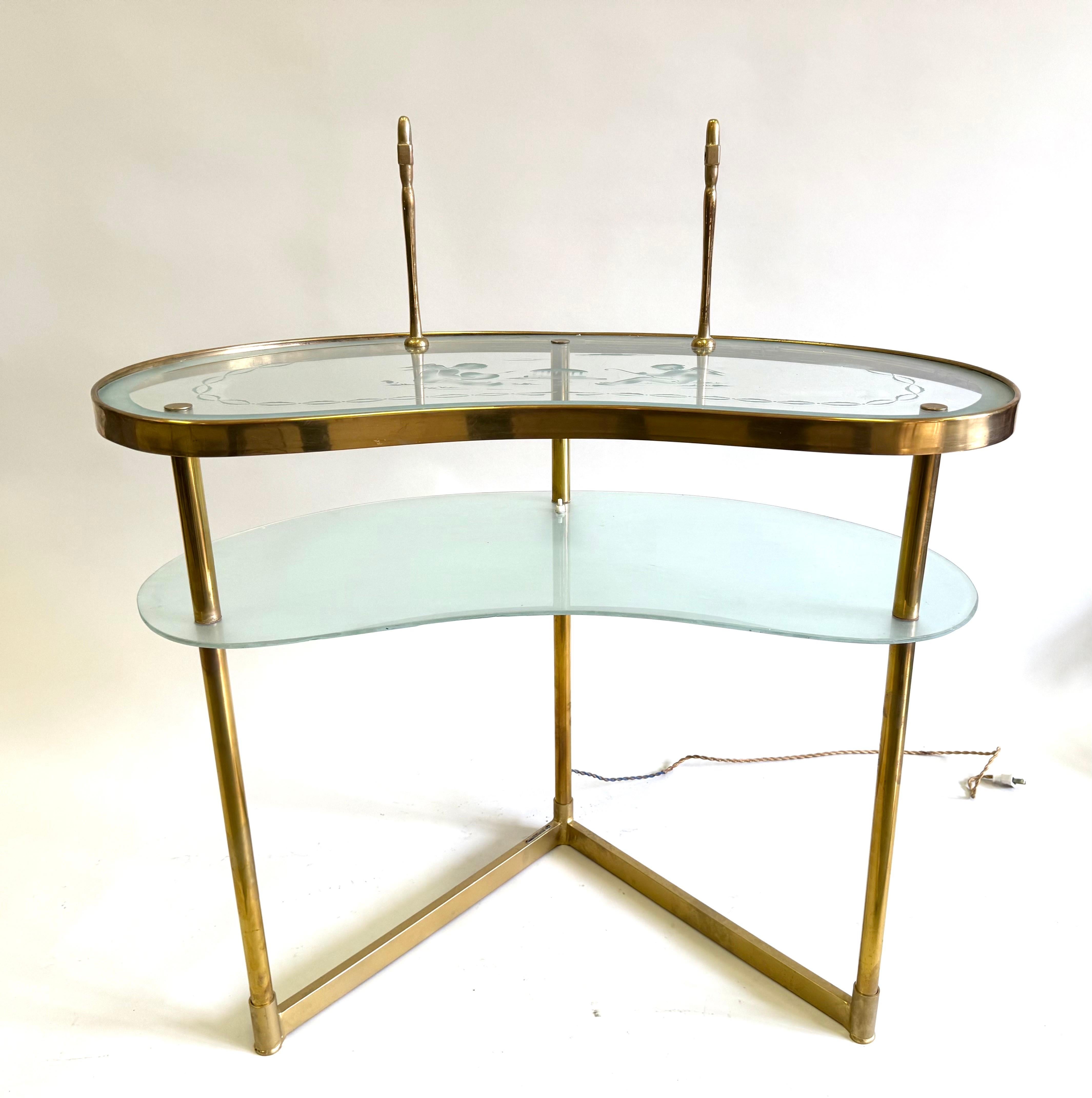 Un elegante tavolino o scrivania in ottone e vetro inciso, nello stile di Max Ingrand per Fontana Arte. Il pezzo presenta una luce squisita e una forma eterea. Sembra fluttuare nello spazio. È composto da due livelli di vetro a forma di rene sospesi