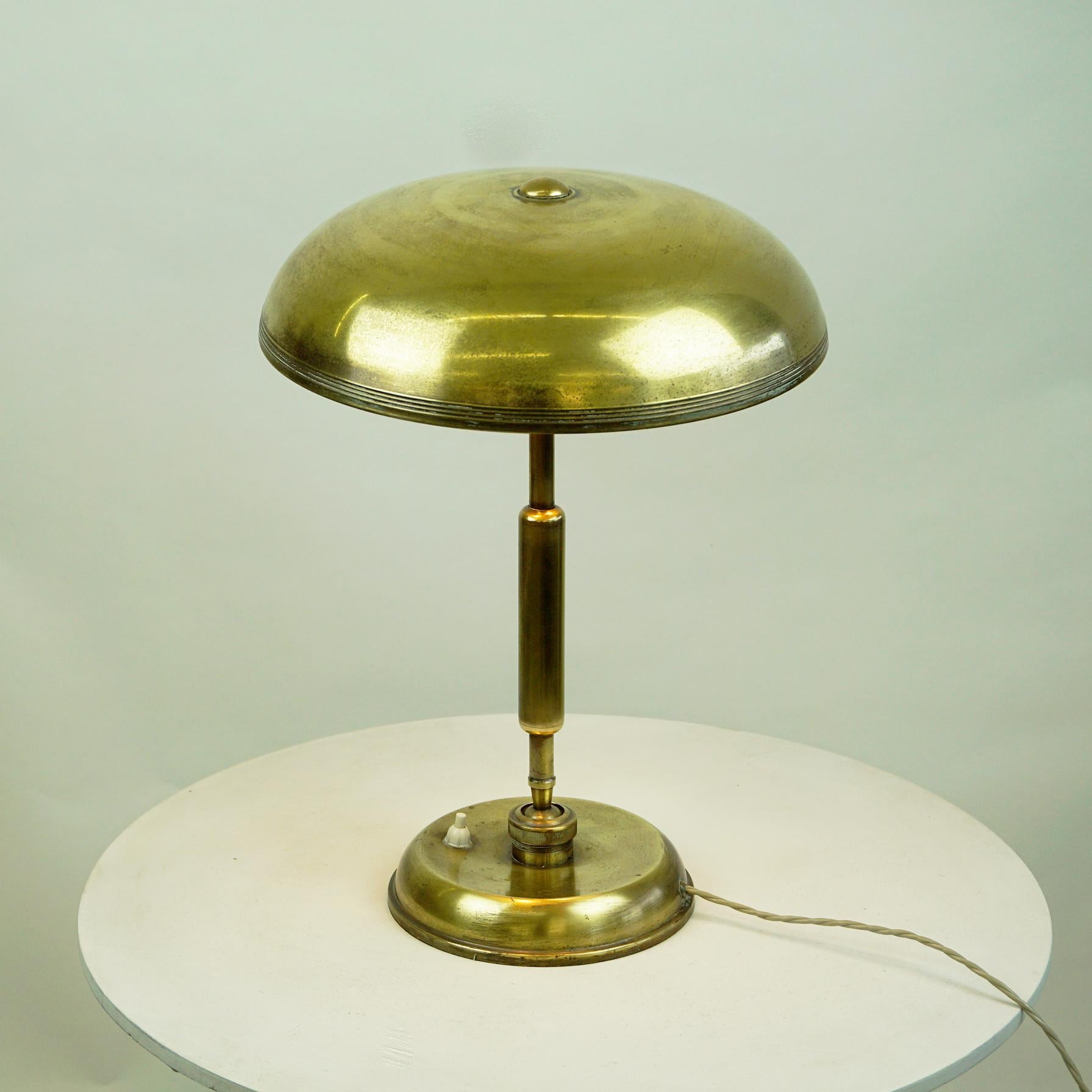 Pre-war Italian brass desk lamp, circa 1940s with a very heavy base, swivel arm and shade in brass metal. A classic desk lamp which combines the characteristics of the Art Deco and Art Nouveau movements. A Lariolux ministeriale rounded shade tops an