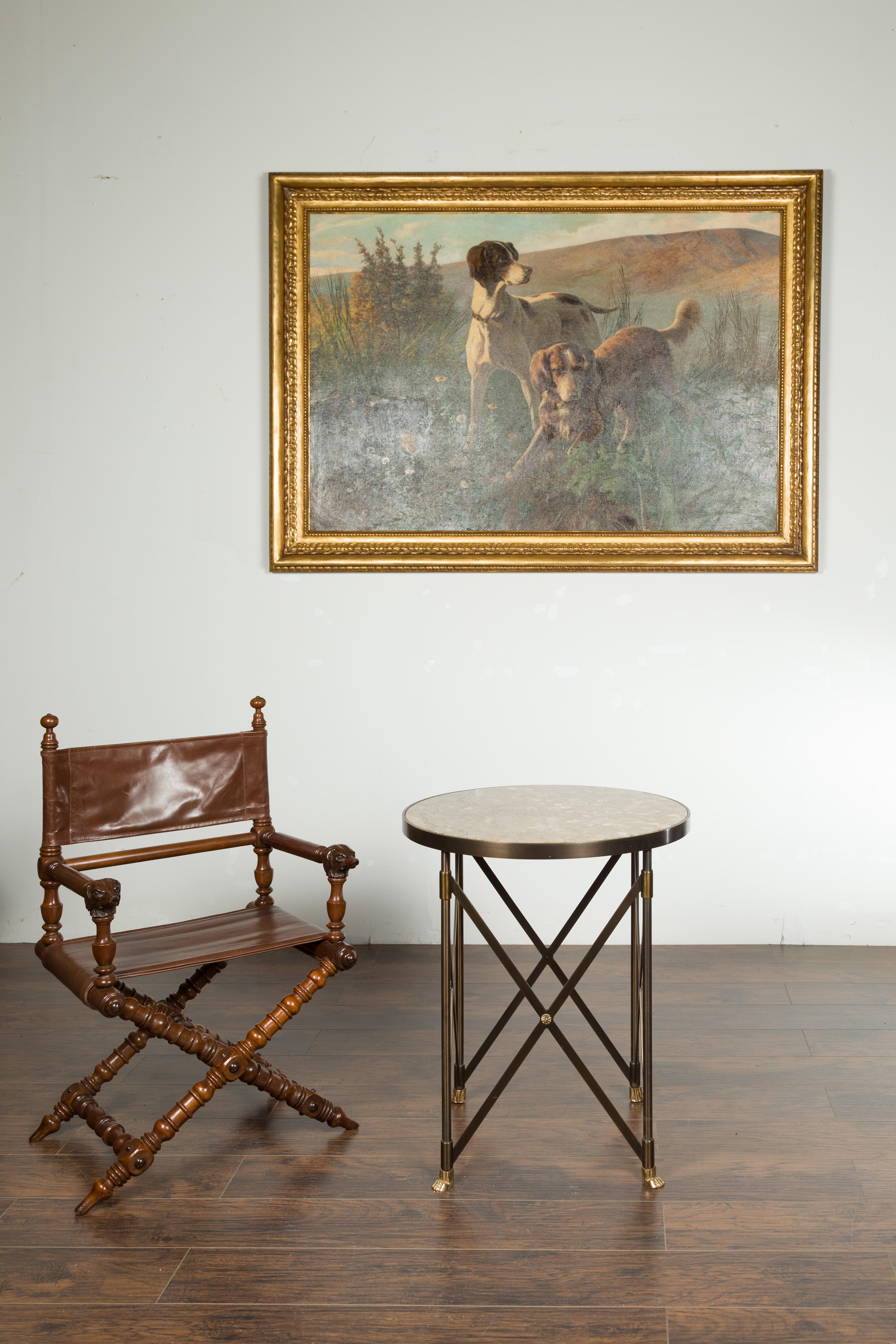 An Italian vintage bronze side table from the mid 20th century, with variegated marble top and paw feet. Created in Italy during the midcentury period, this side table features a circular marble top sitting above a bronze side table with X-form