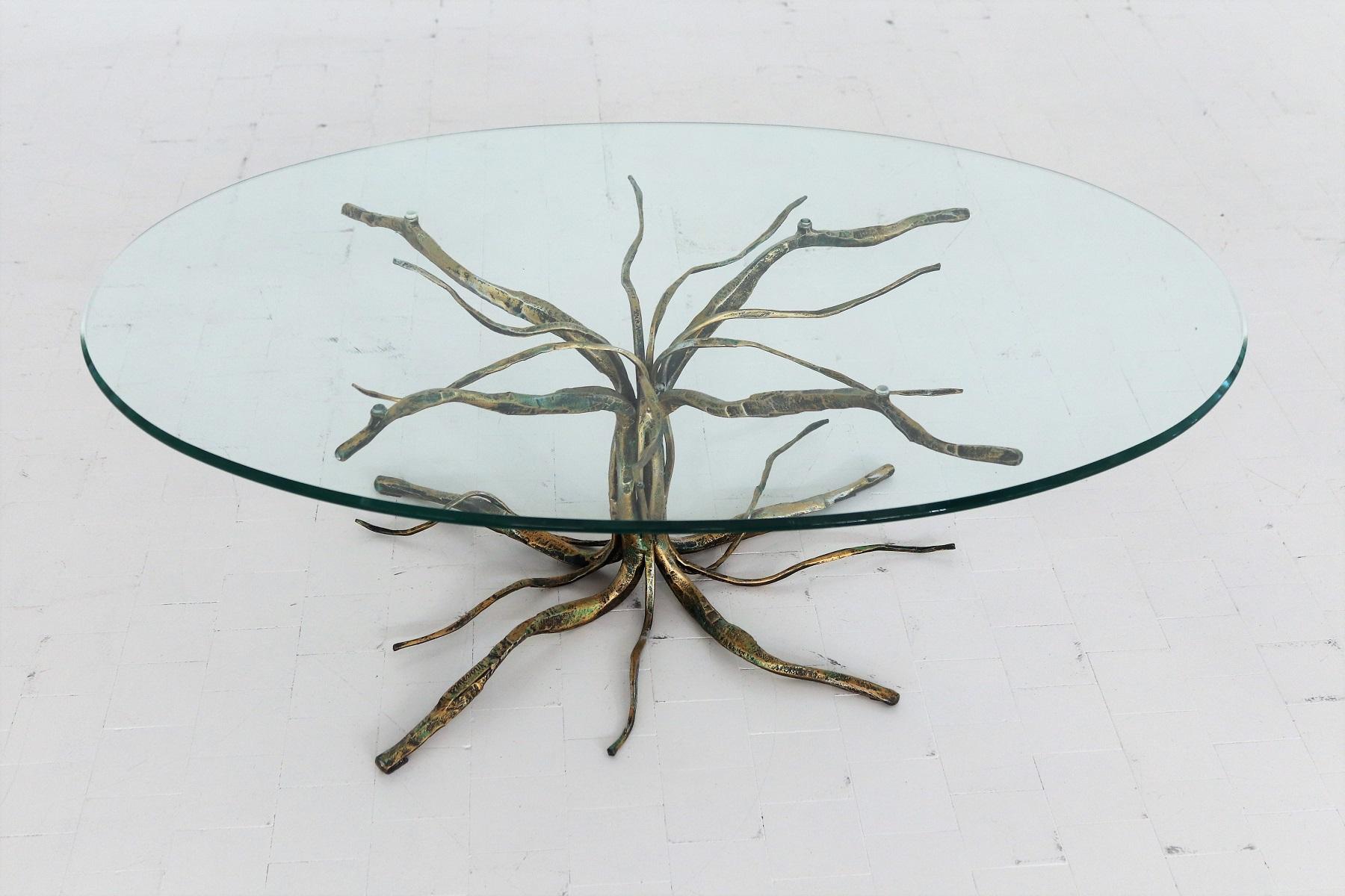 Gorgeous coffee table handcrafted by Italian Artist and Sculptor Salvino Marsura, who passed away in May 2020.
The coffee table shows an amazing tree in heavy gilt wrought iron.
On top is the original crystal glass top with cut edge.

The table is