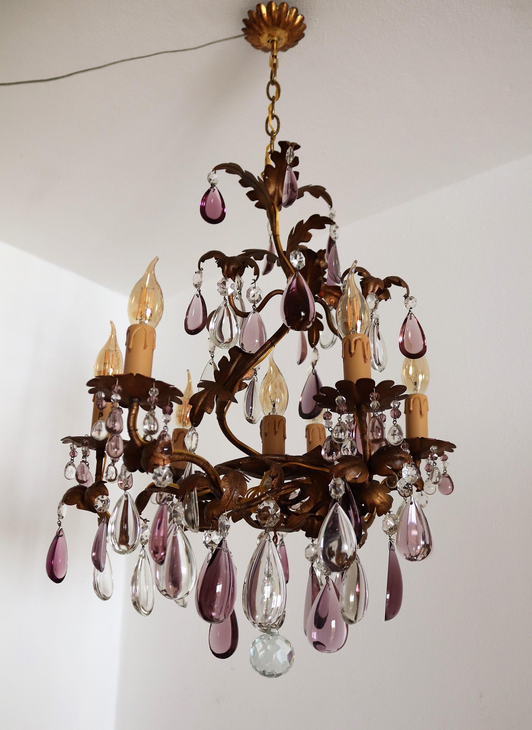 Gorgeous Chandelier in the shape of a tendril with Leaves.
Made in Italy in the 1950s. 
The chandelier is made of strong, partially gilt metal and has 7 light bulbs for small size bulbs.
The purple and transparent drops are original old Murano