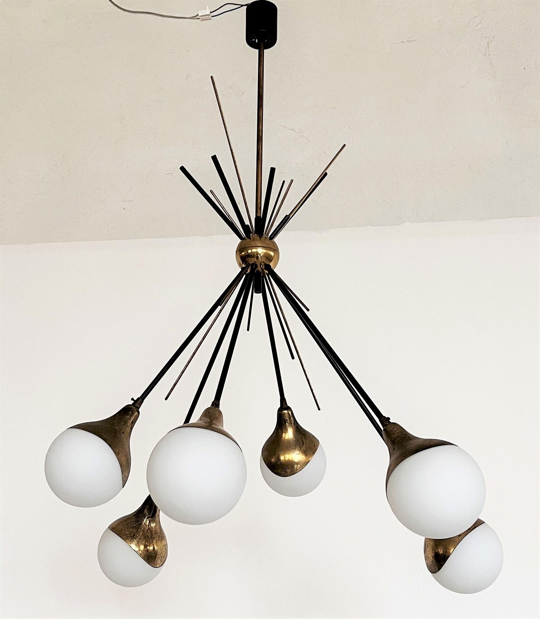 Beautiful original chandelier from Italy of the 1950s.
Made by the famous design manufacturer Stilnovo Italy.
The chandelier has a frame of brass and metal, partially painted black, which is built like a sputnik.
At the end of the long brass rods