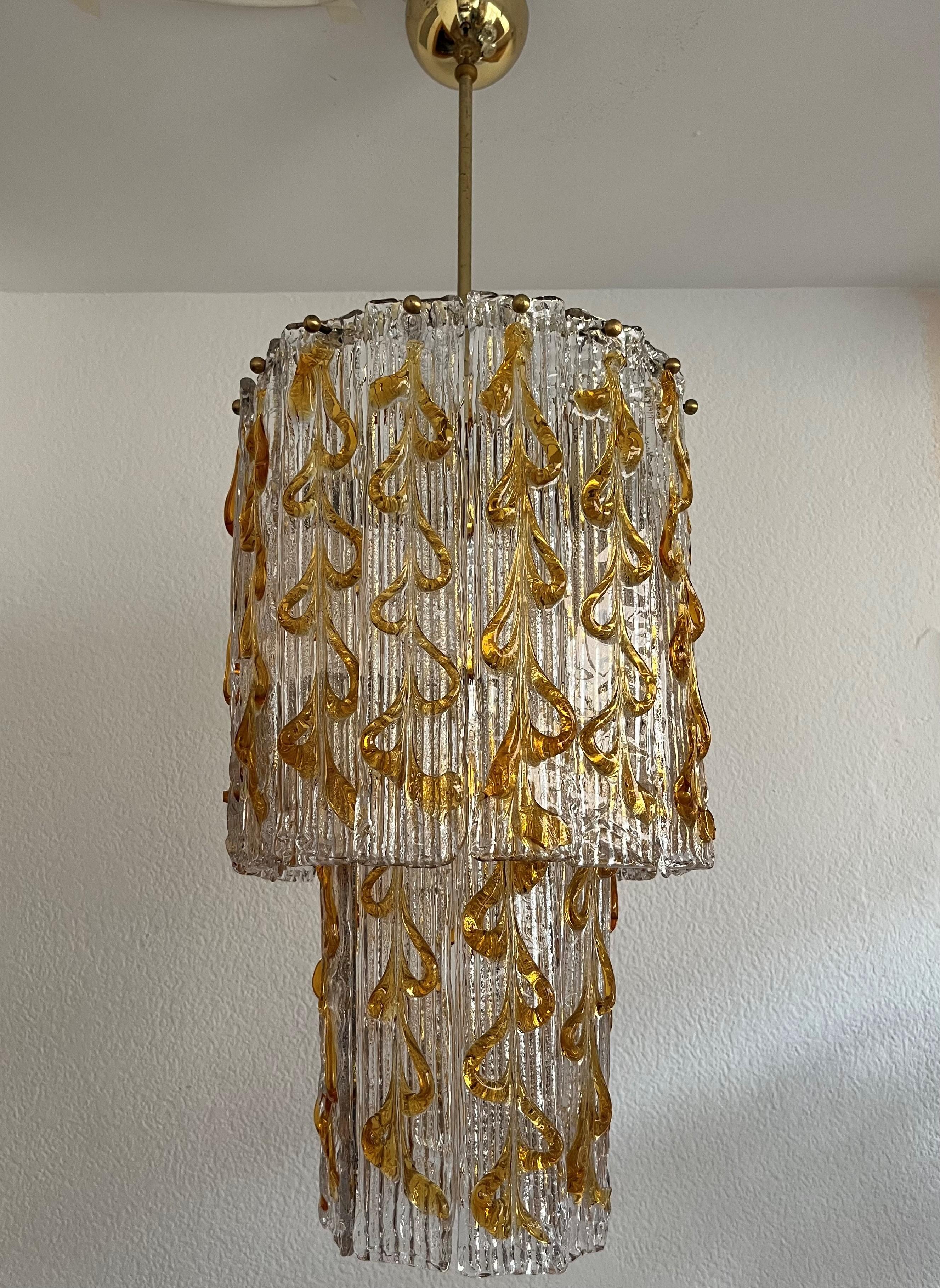 Lovely and beautiful Italian clear amber Murano glass Chandelier from 1970s. This fixture was made during the 1970s in Italy.
This fixture is composed by 24 clear amber murano glasses.
This Chandelier is equipped with 4 light sockets E27. A