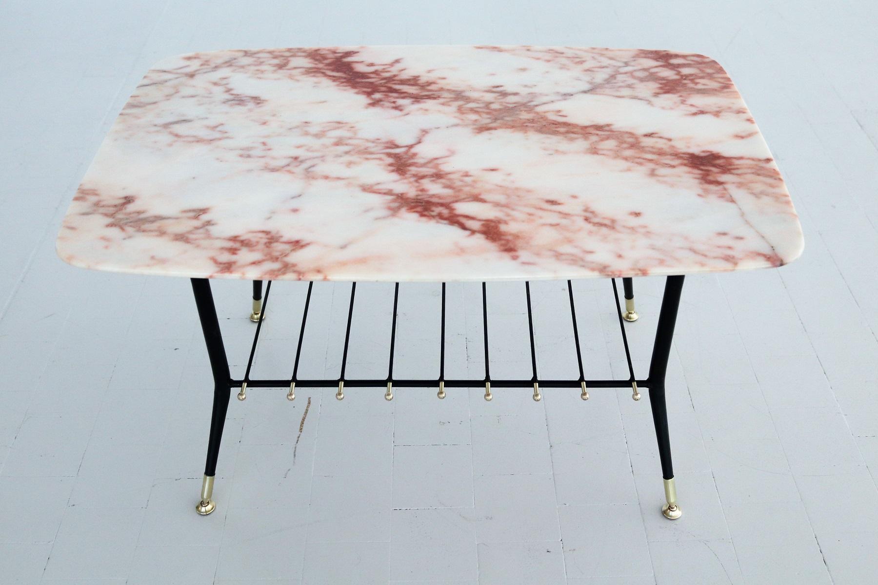 Beautiful coffee table with gorgeous marble top with pink veins and magazines tray in metal with brass tips and details.
Made in Italy during the 1970s.
The marble is called pink Portugal marble and has a beautiful natural marble design with