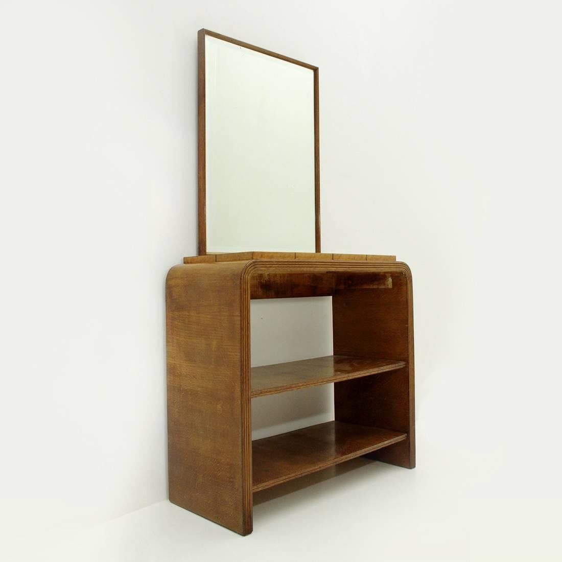 Italian console produced in the 1940s.
Structure with curved corners in veneered wood.
Raised top veneered with briar panels.
Grissinato front edge.
Two lower shelves.
Mirror with wooden frame with edges cut at 45°.
Structure in good