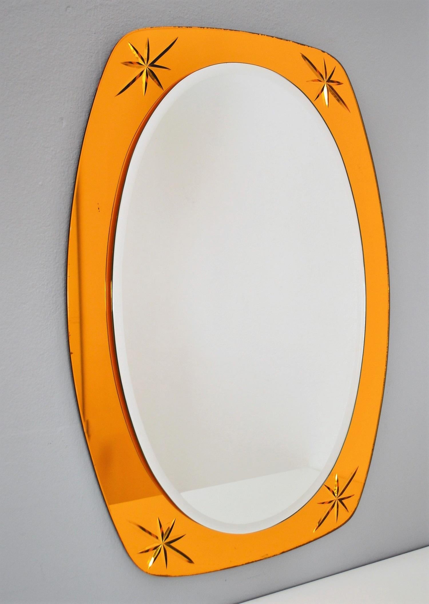 Gorgeous wall mirror with stunning shiny golden - yellow color.
Typical work of the 1960s, Made in Italy.
The mirror is made of two glass layers, the upper one is with cut border all around.
The bigger, golden-yellow one, has 4 cut stars inside