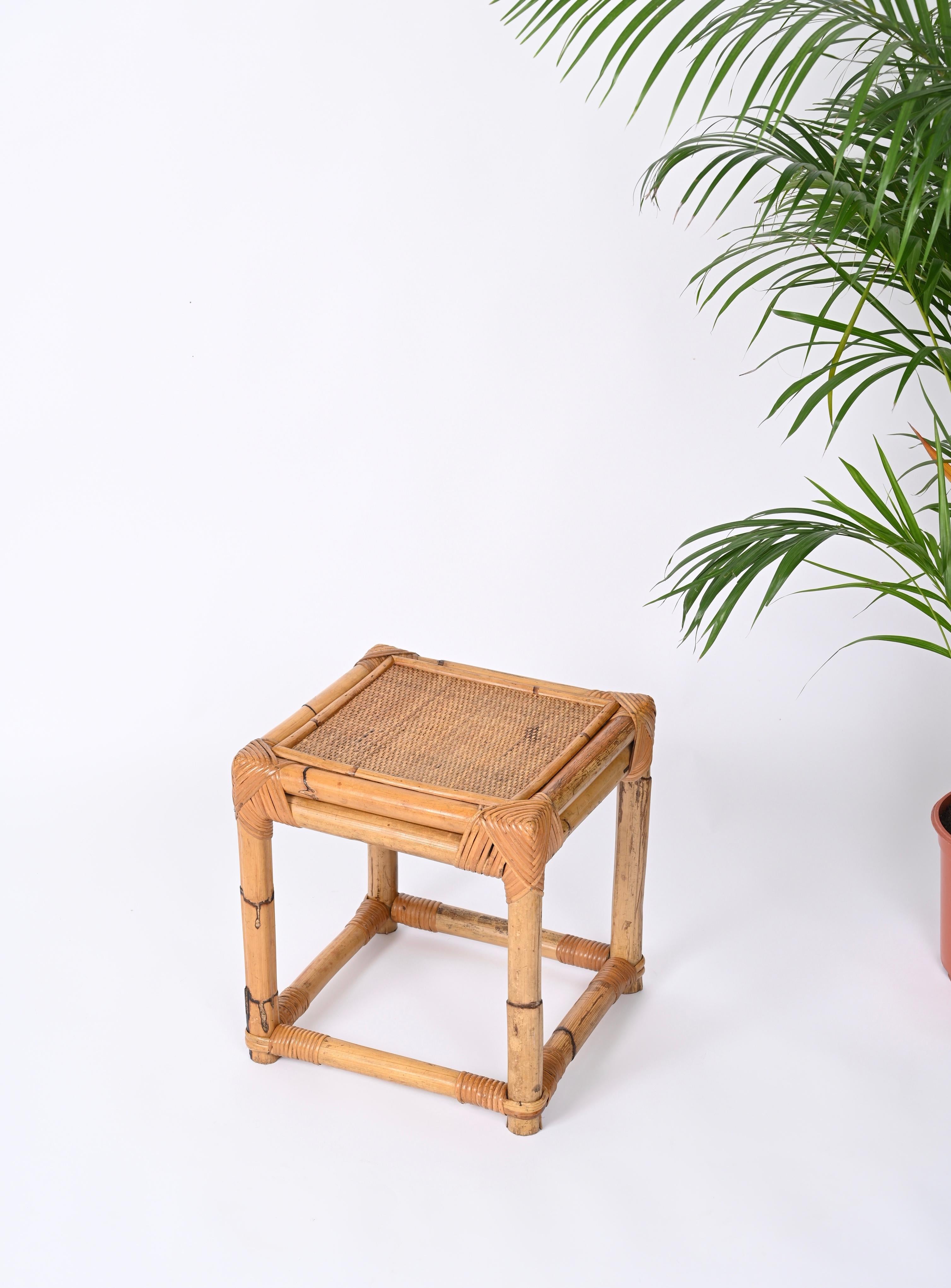 Hübscher kleiner Beistelltisch oder Hocker aus Bambus und Rattan, hergestellt in Italien in den 70er Jahren.  

Diese robuste Ottomane hat eine würfelförmige Struktur, die vollständig aus Bambusrohren gefertigt ist. Die Oberseite besteht aus einem