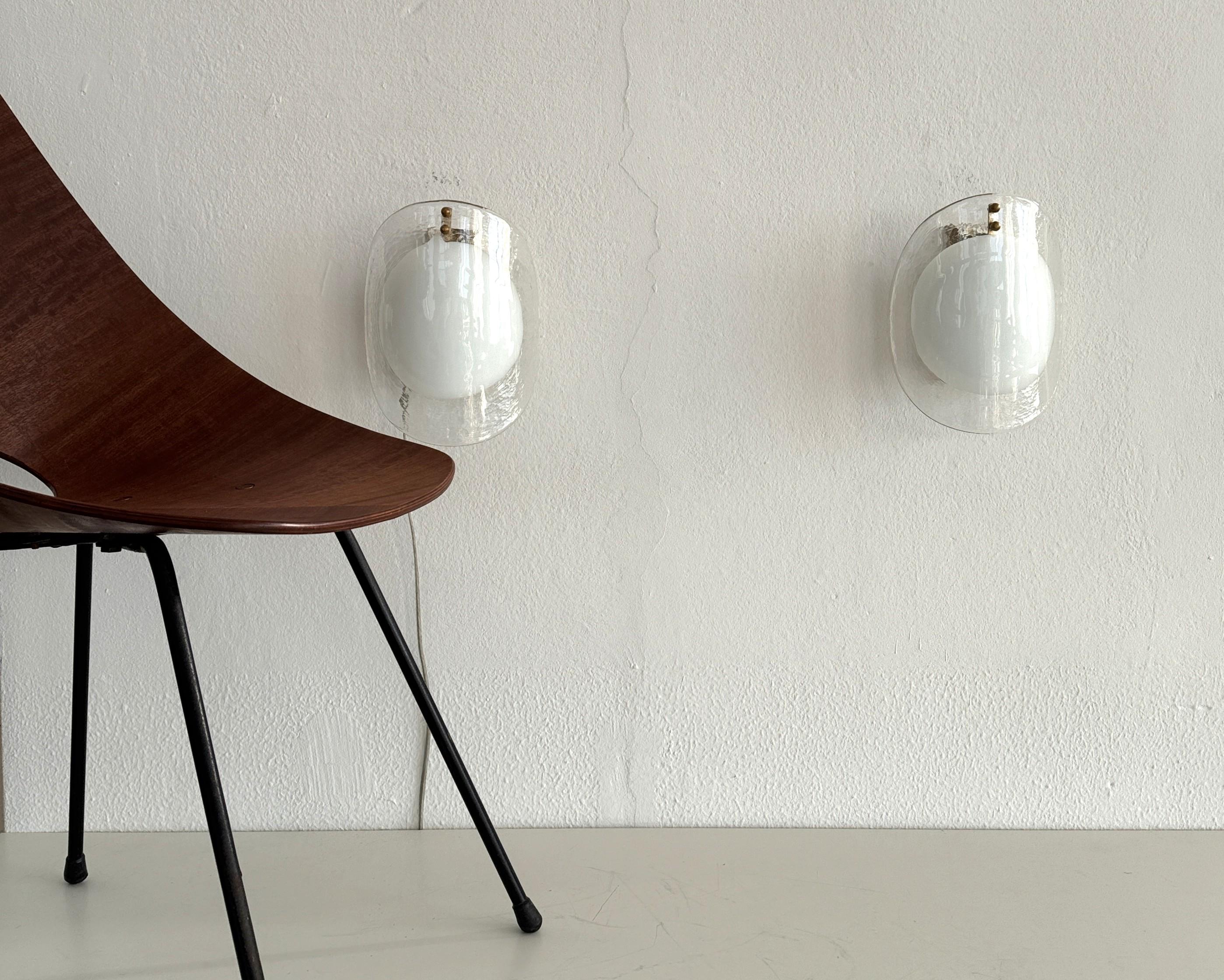 Applique in vetro di Murano di design italiano del Medioevo, anni '70

Una coppia di applique di design dall'incantevole effetto visivo, tipico del design italiano.
Realizzato in Italia, a Murano, negli anni '70.
I paralumi curvi in vetro luminoso