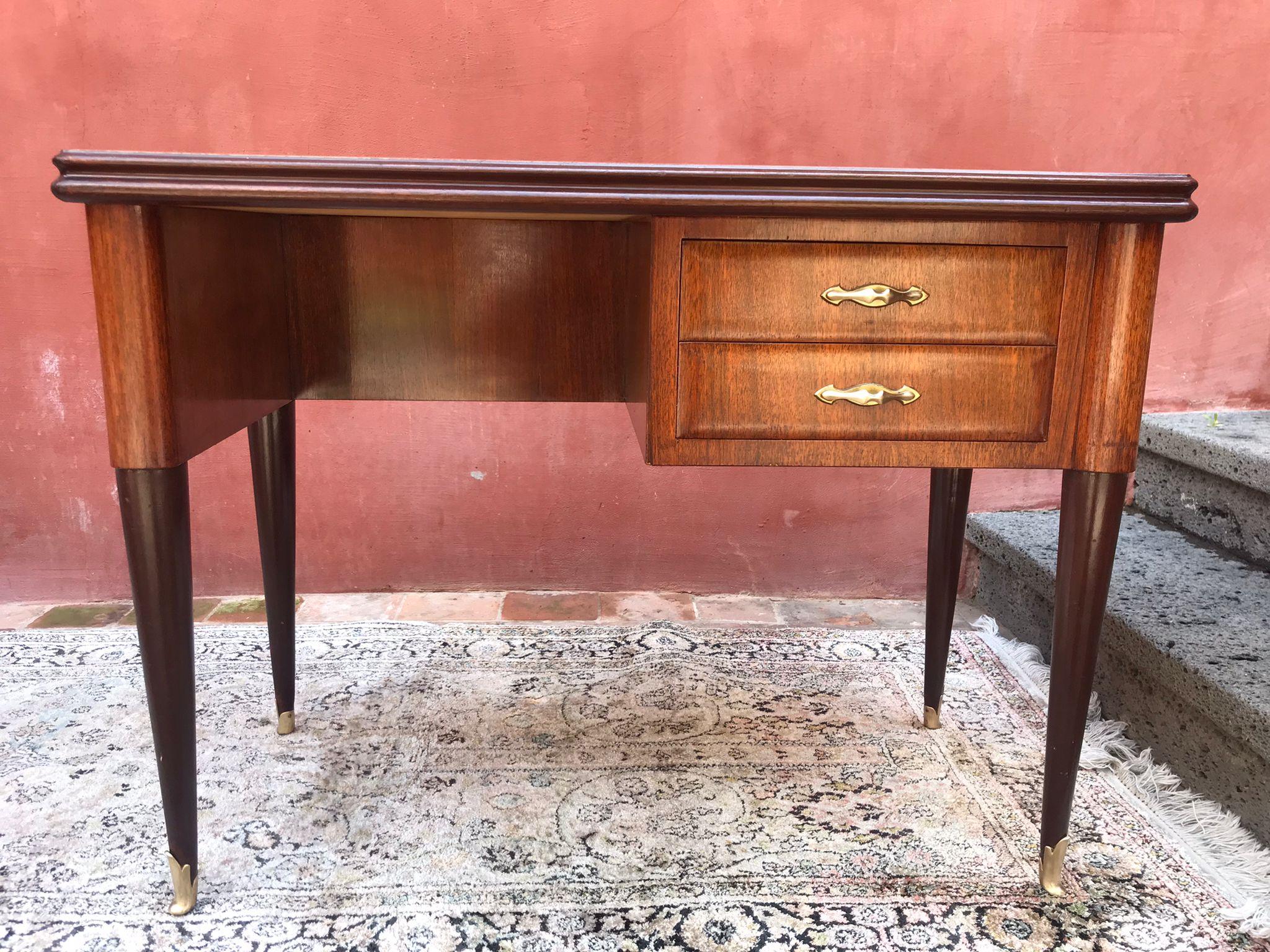 An Italian designed small writing desk in walnut,. Fantastic proportions on sculptural legs tapering to brass final on the feet. Two drawers with brass hardware with strawberry red glass top,
Attributed to Carlo De Carli, circa 1950.
In good