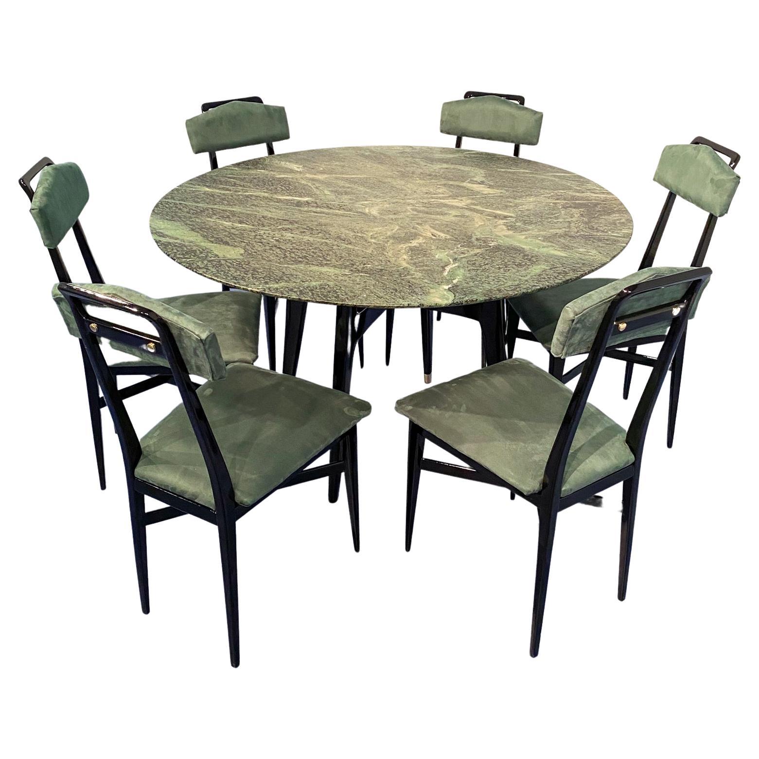 Beautiful dining set composed of dining table and dining chairs.
This stylish mid-century round marble dining table is a stunning example of 1950s Italian design.
The top is crafted from precious green marble from the Alps.
The black lacquered
