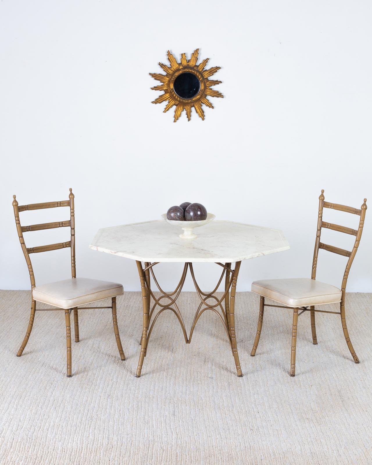 Gorgeous Italian Mid-Century Modern dining table featuring an octagonal marble top. The unique table has a faux bamboo iron base with a painted finish. The curved legs are conjoined by multiple curved stretchers in a star form at the center. The