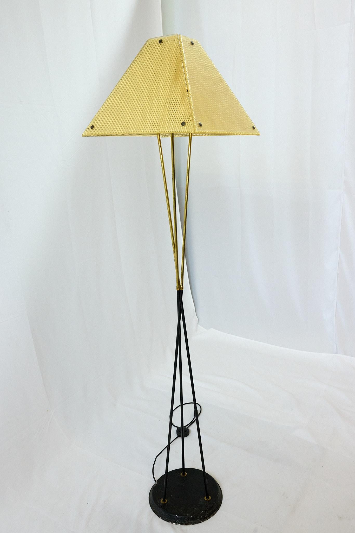 Lampadaire trépied italien du milieu du siècle en fer et laiton avec l'abat-jour original en résine translucide à quatre panneaux avec un design classique en forme de panier. 

La lampe mesure 69