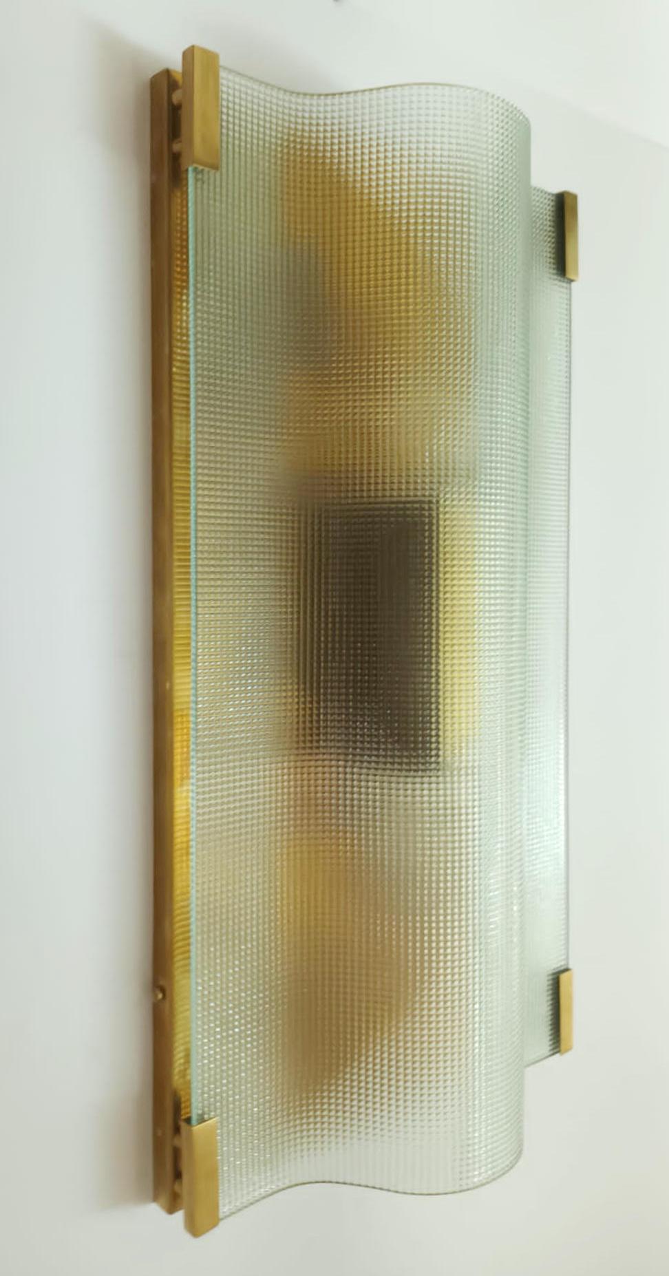 Vintage Italian wall light with textured curved glass diffuser mounted on brass frame / Made in Italy, circa 1970s
2 lights / E26 or E27 type / max 60W each
Measures: height 21.5 inches, width 12 inches, depth 4 inches
1 available in stock in Italy
 