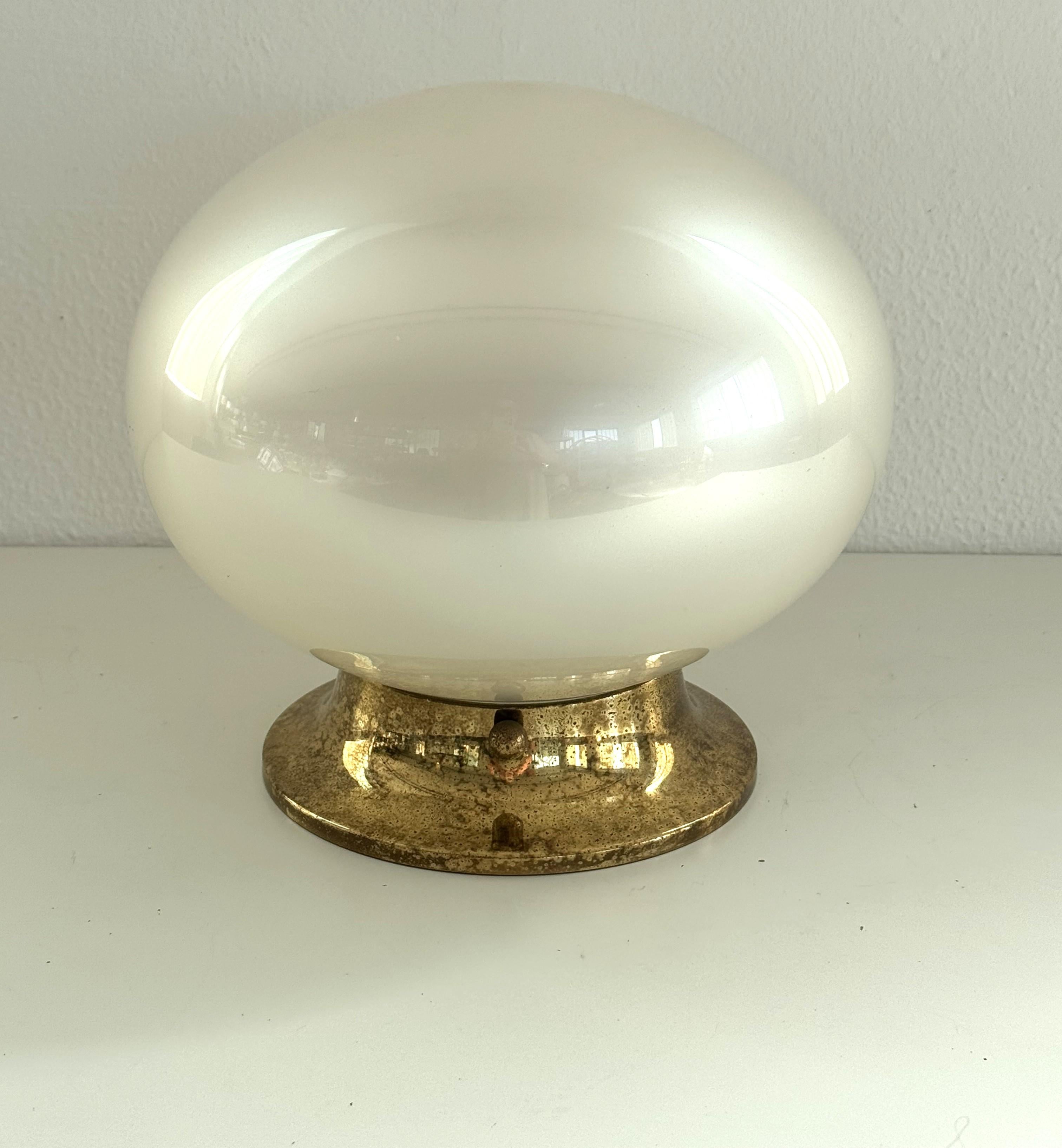 Italian Midcentury Flush Mount Light with Brass Base, 1970s

Beautiful flush mount light with blown mother of pearl glass globe and brass base.
Made in Italy in the 1970s.
The glass globe is mounted with 3 big brass screws to the brass base, which