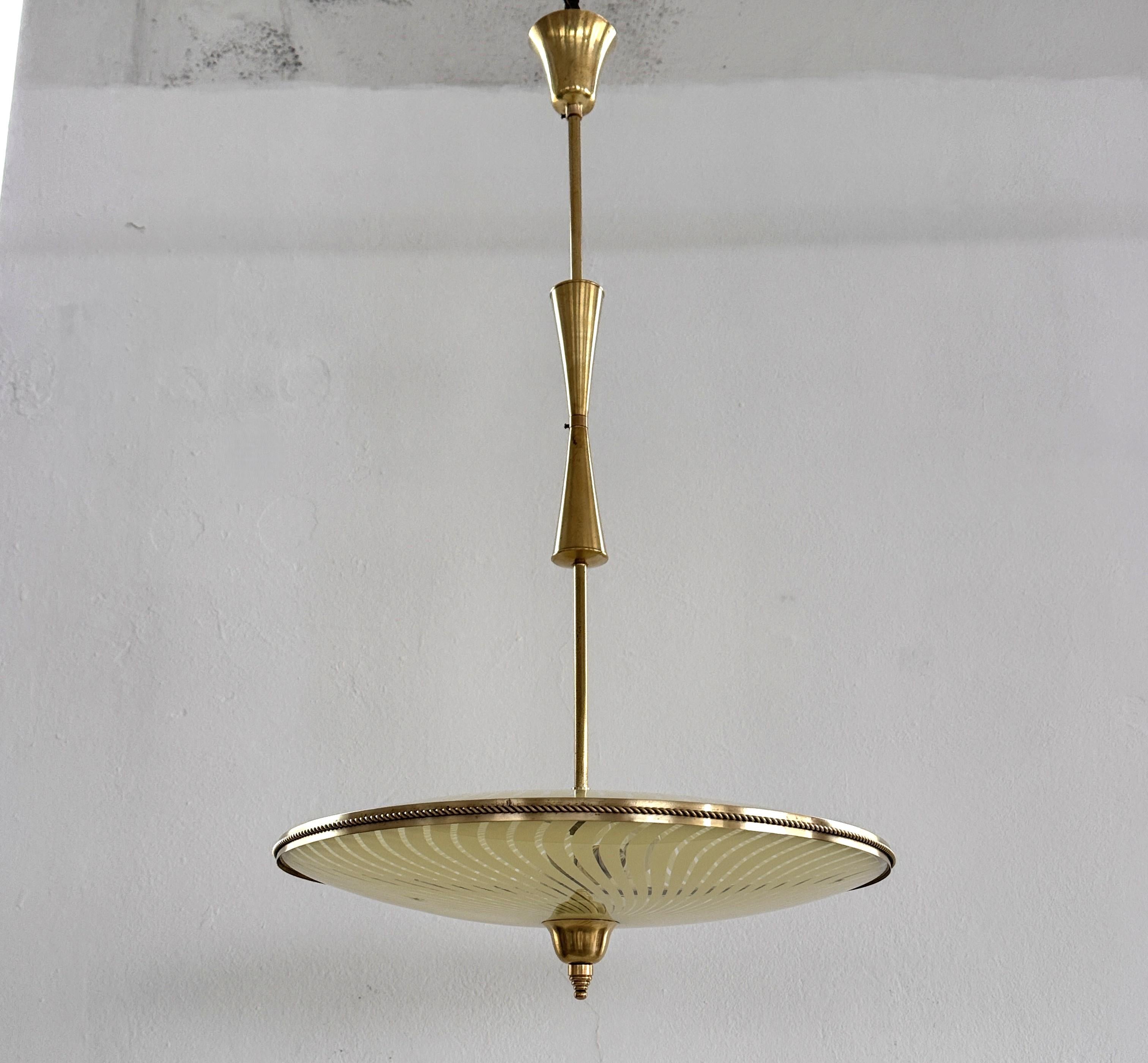 Lampada a sospensione 'Ufo' in vetro di Murano e ottone di Fontana Arte, 1950

Bellissima lampada a sospensione italiana realizzata in Italia negli anni '50, attribuita alla manifattura Fontana Arte.
Il lampadario è composto da due lastre di vetro